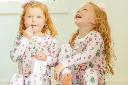 2 little girls in Christmas pajamas laughing
