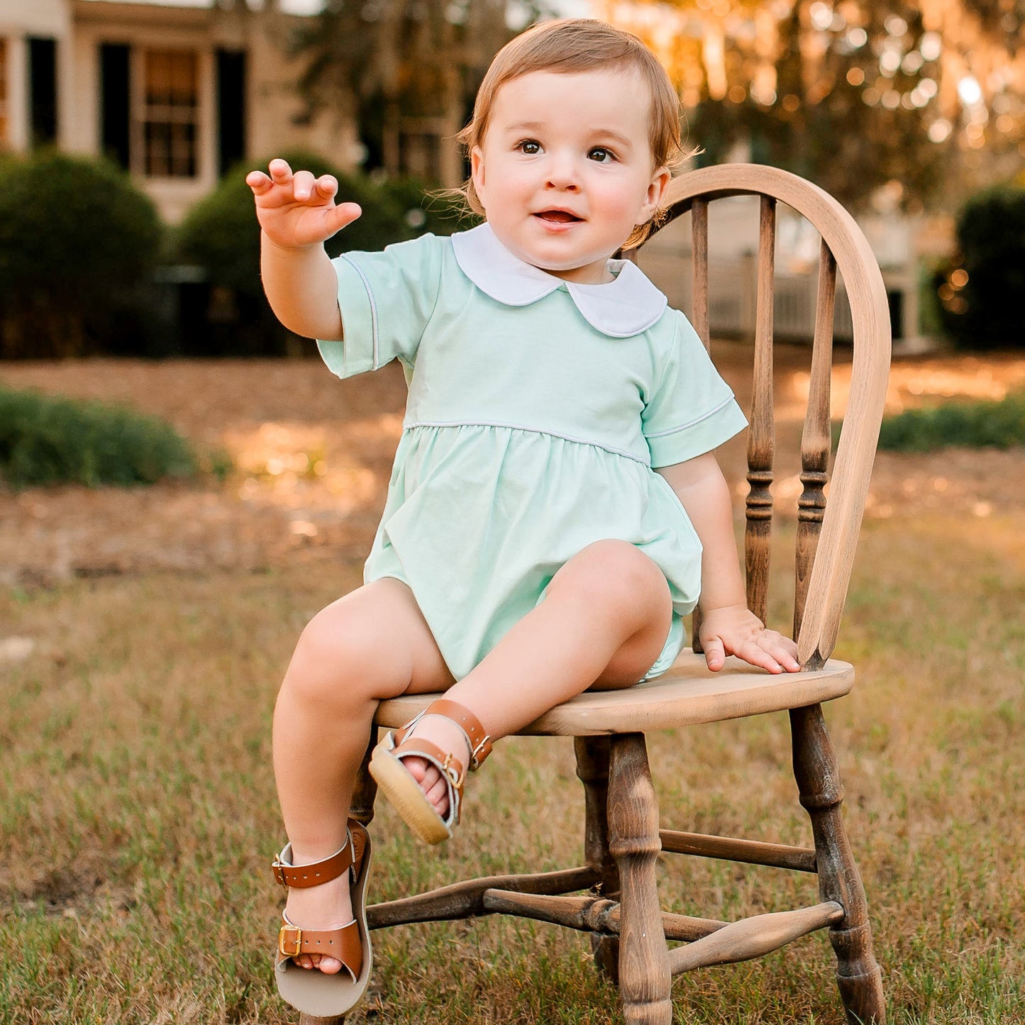 little boy in Aqua Bubble sitting in a chair in the grass