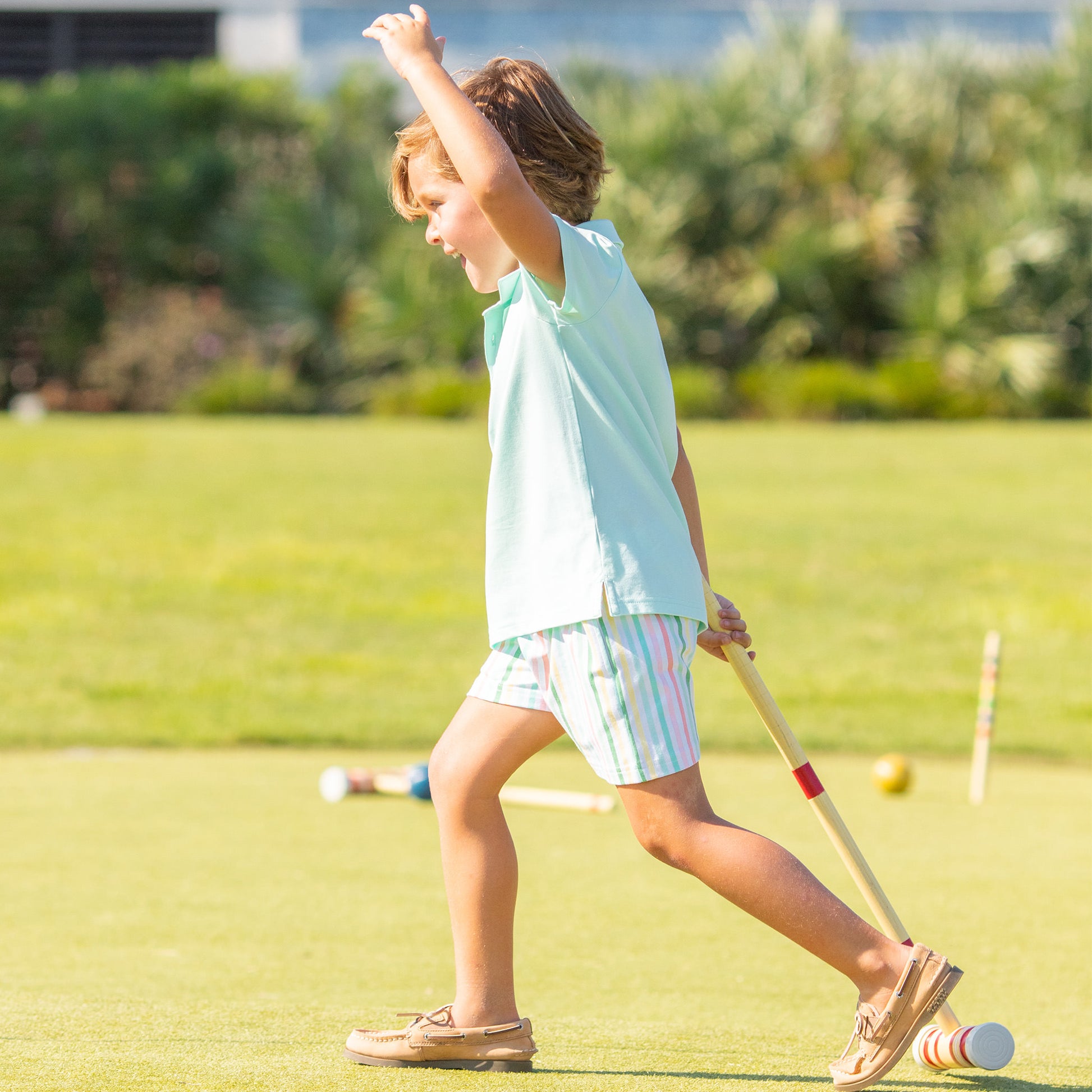 little boy playing croquet wearing Beach Club Stripe Shorts