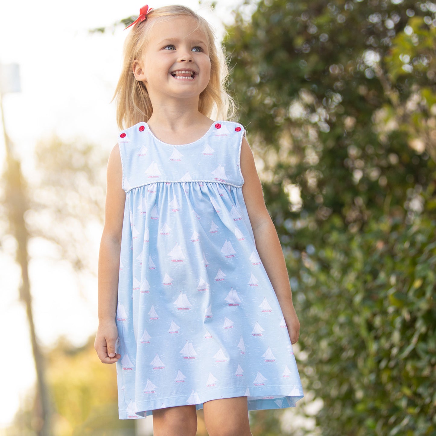 little girl smiling walking down the sidewalk