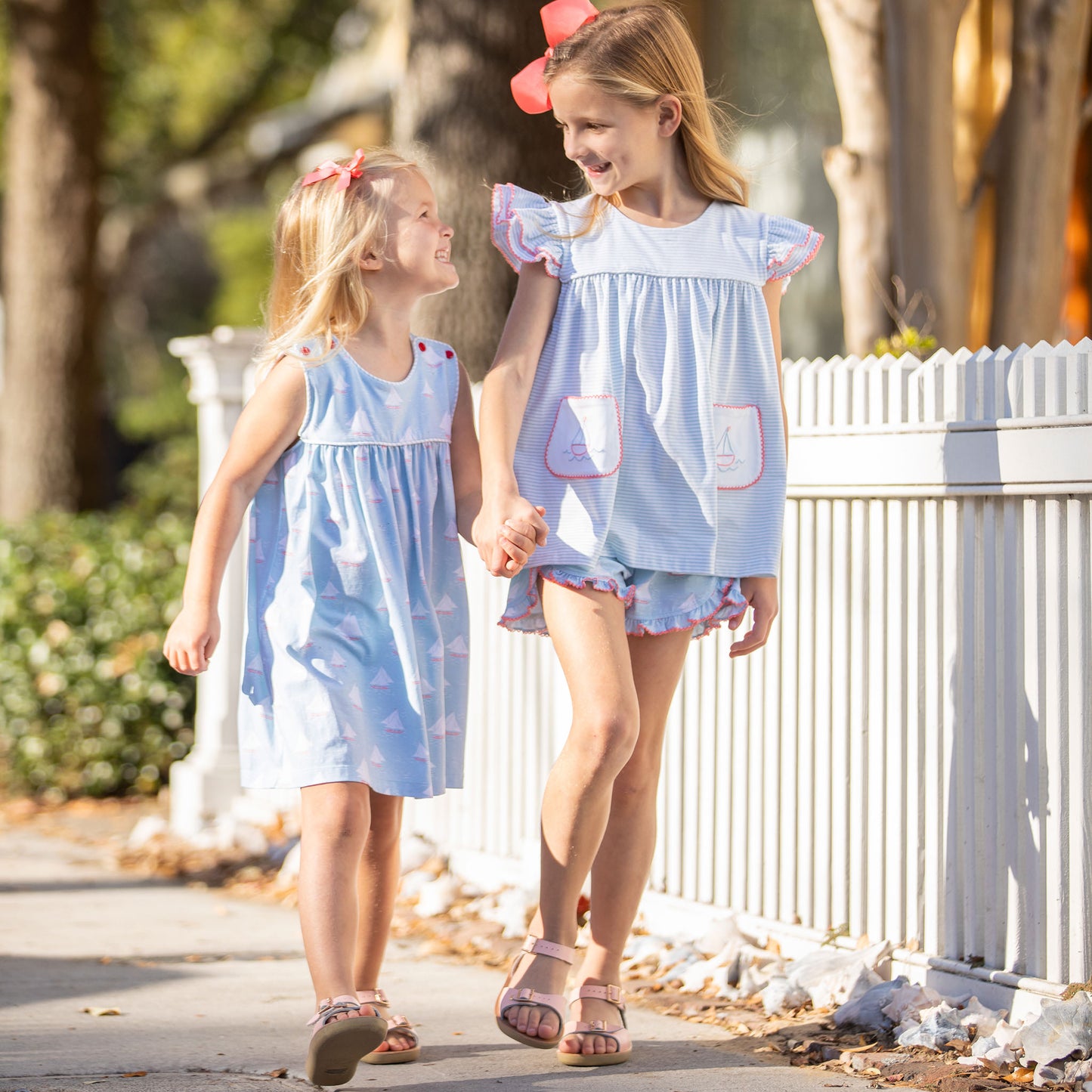 little girl wearing Botany Bay Button Dress holding h ands with another little girl