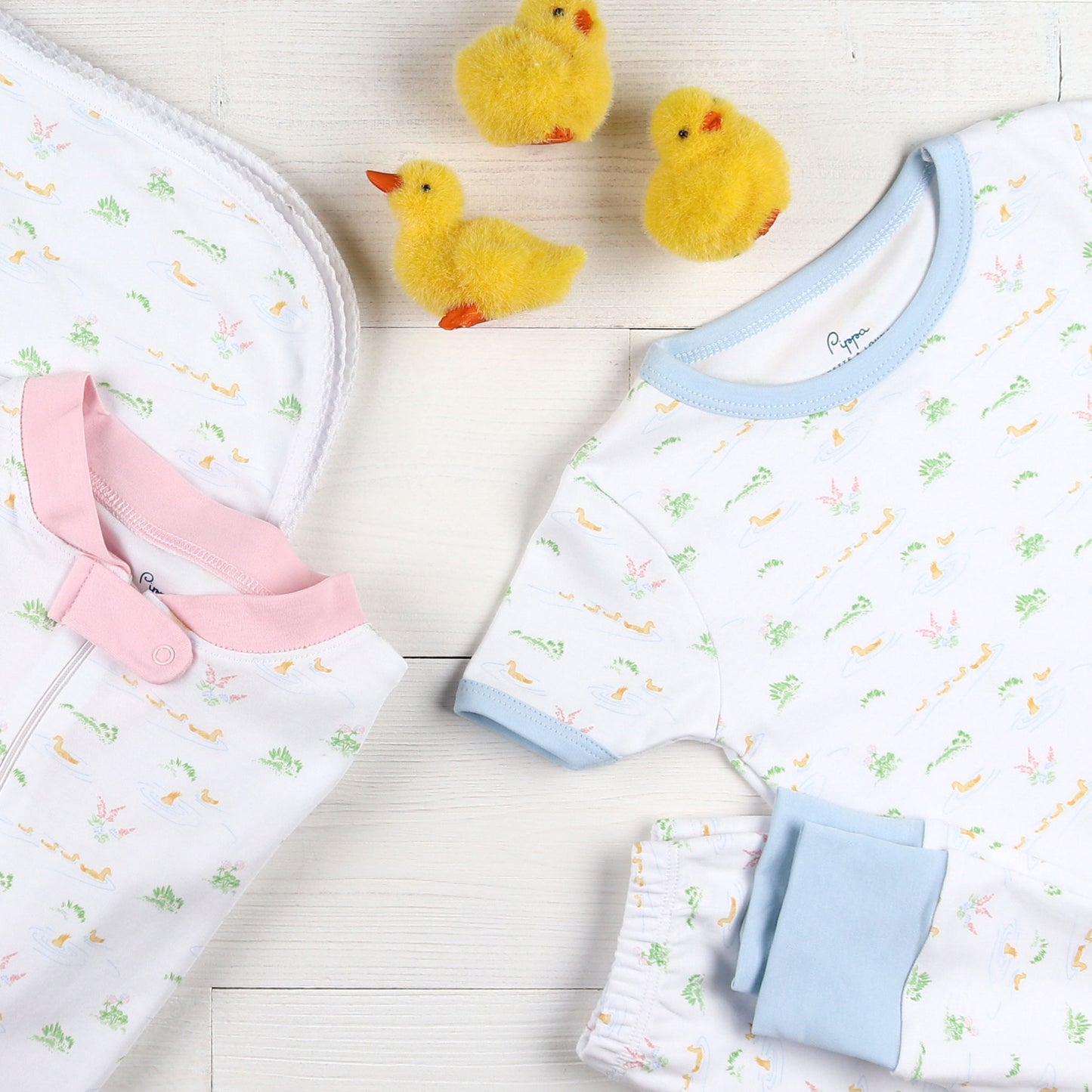 flatlay of Ducky Blue Pima Loungewear Set and stuffed duckling toys