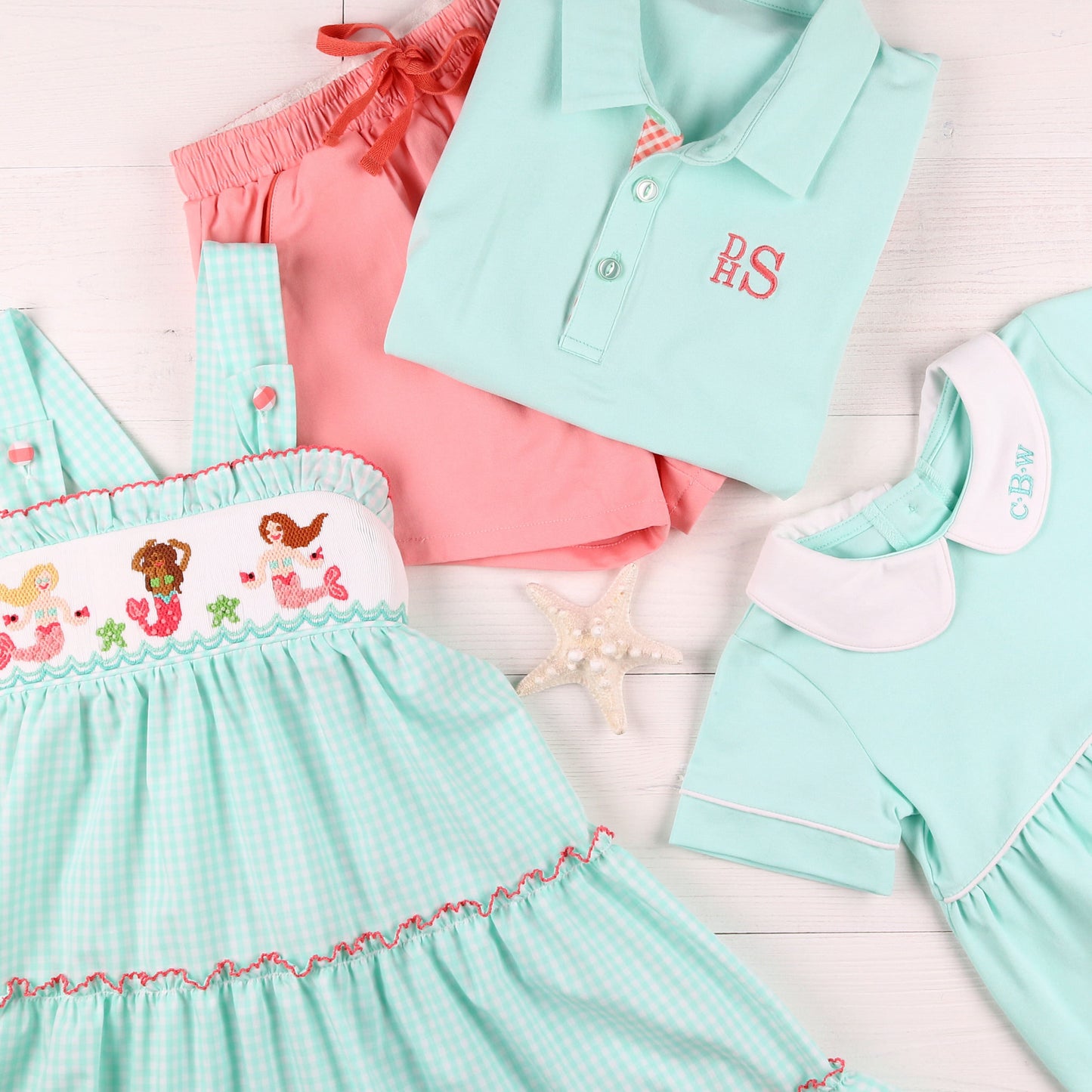 flatlay of a monogrammed shirt, shorts and dress and Aqua Bubble