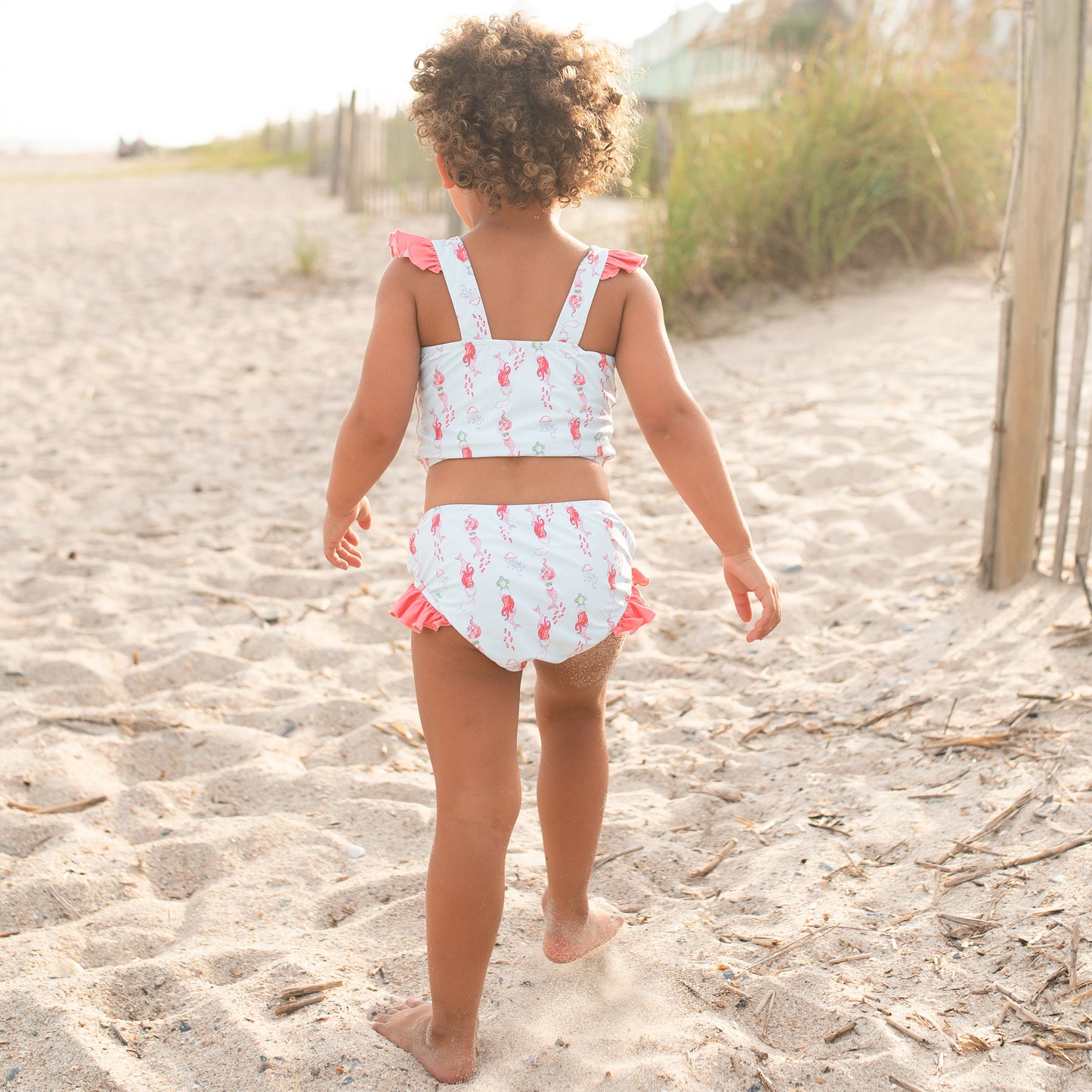 little girl walking on the beach wearing her Girls Under The Sea Bikini