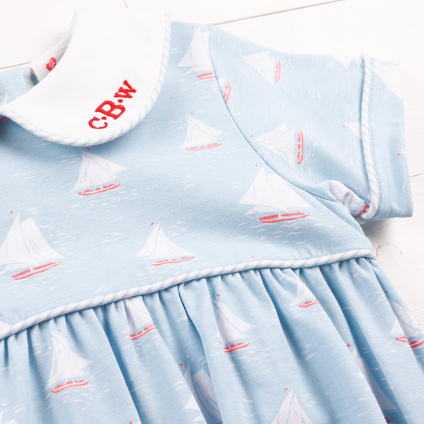 close up of a sailboat jumper with a red monogram on the collar