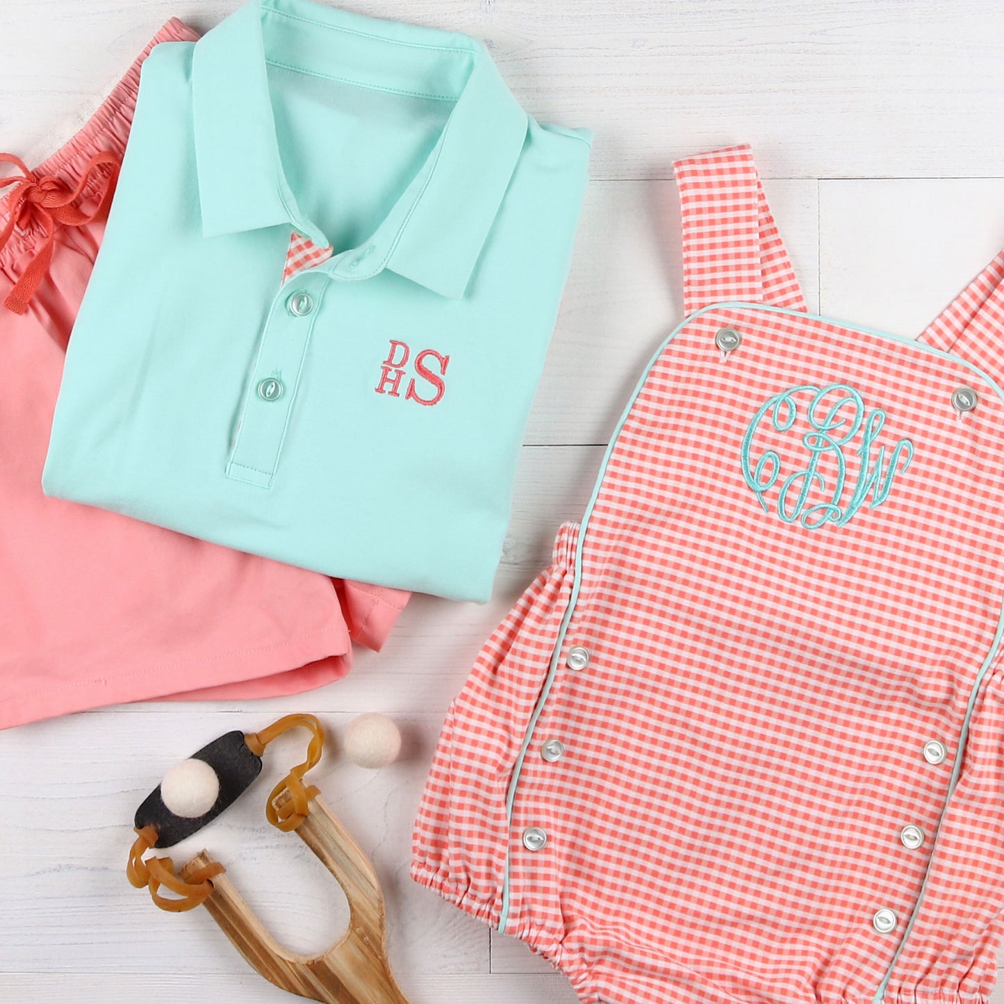 flatlay of Boys Aqua Polo Shirt with a monogram, shorts and monogrammed checkered bubble
