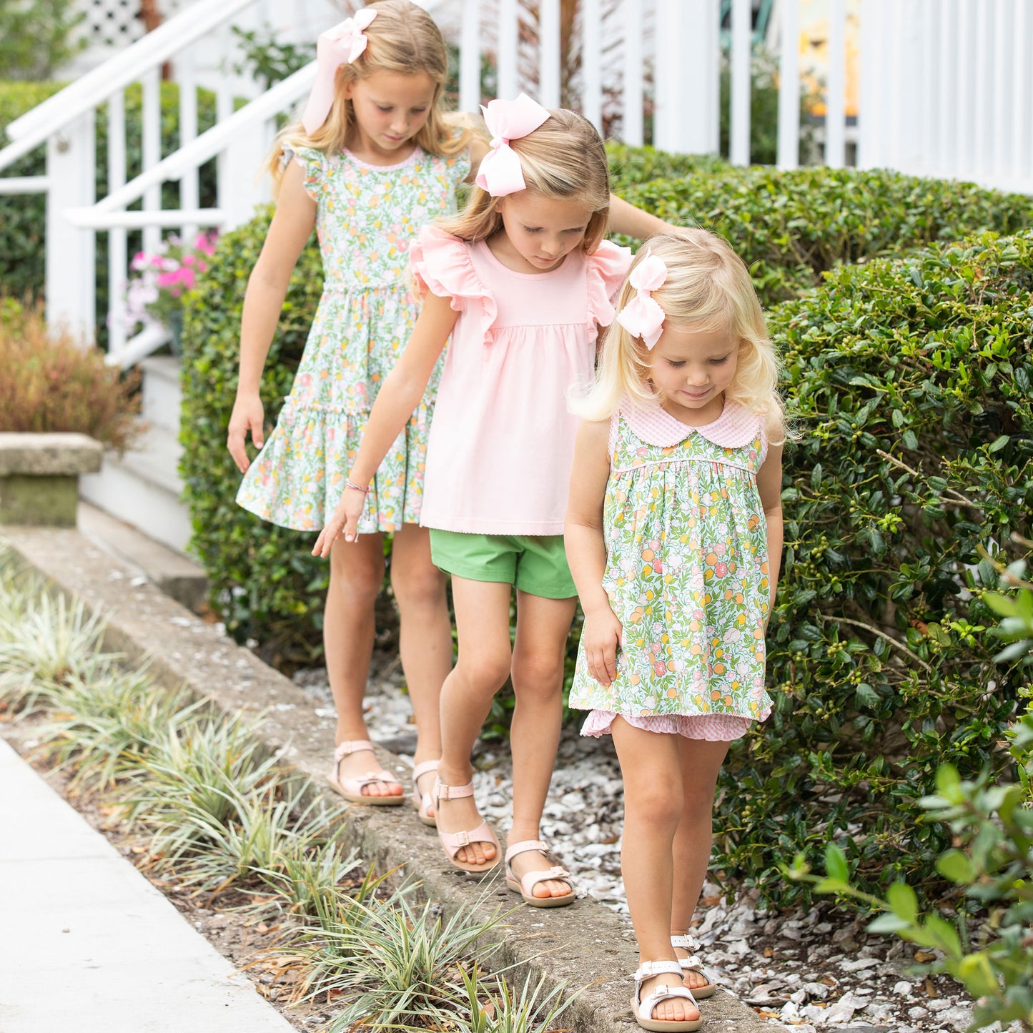 3 little girls walking down the sidewalk