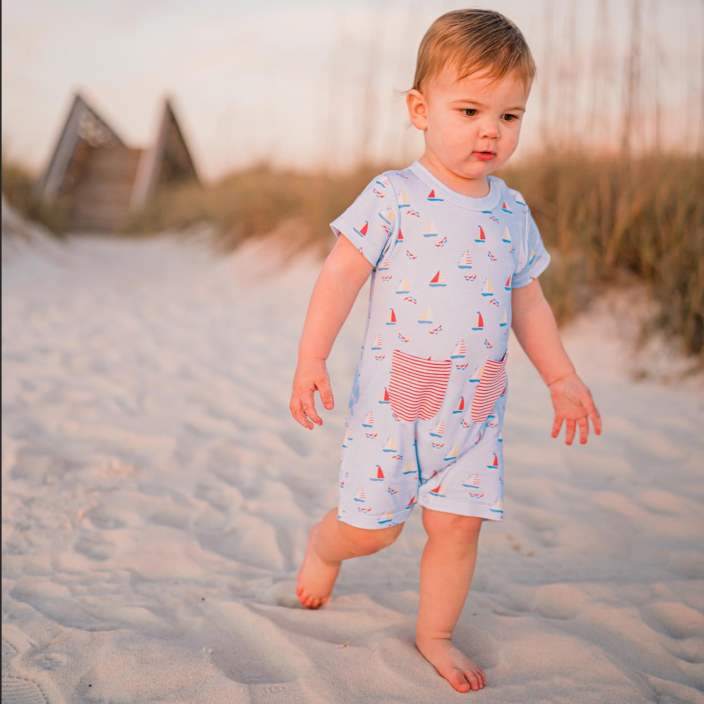 little baby walking in the sand at the beach