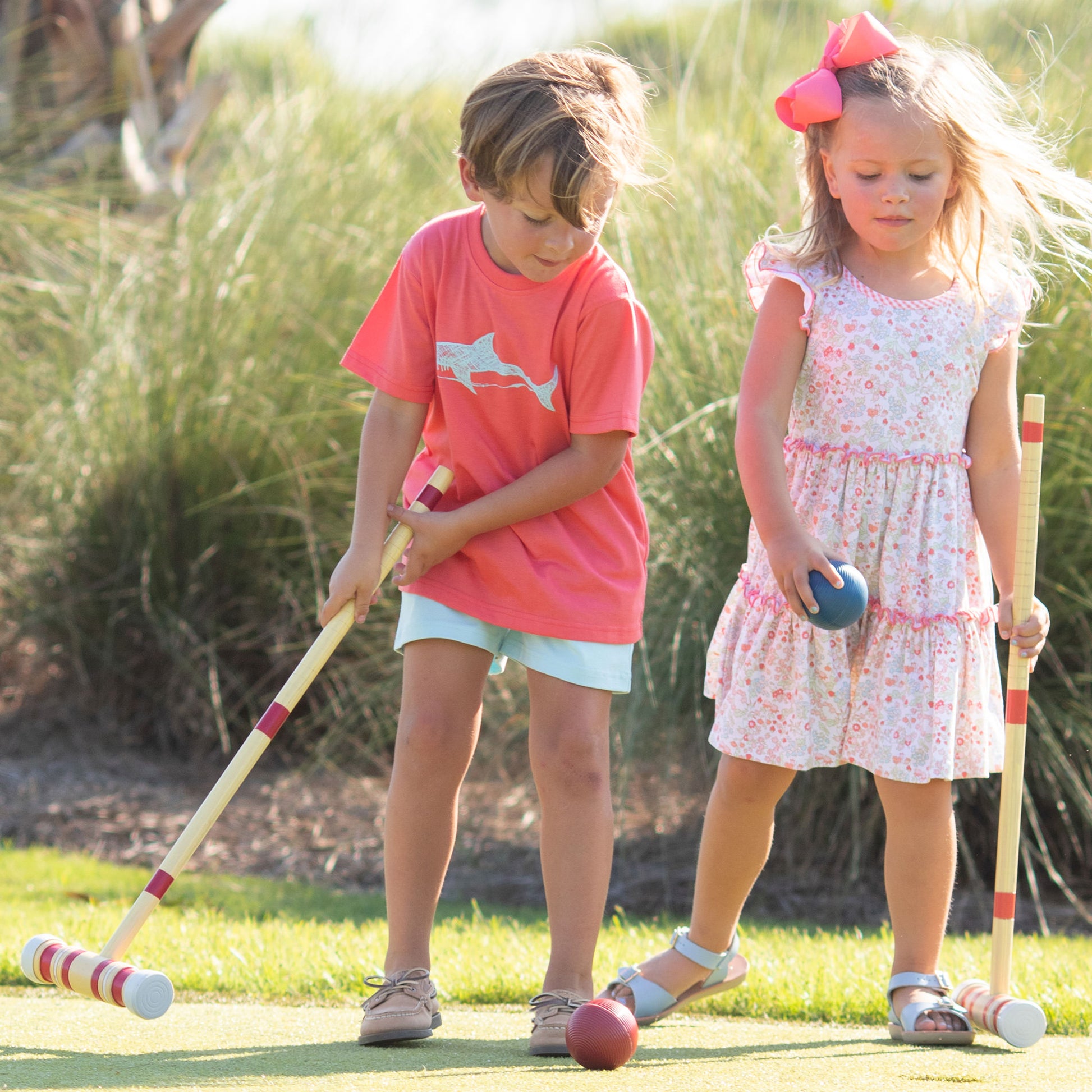 little boy in a shark shirt and Briggs Blue Knit Shorts playing croquet with a little girl