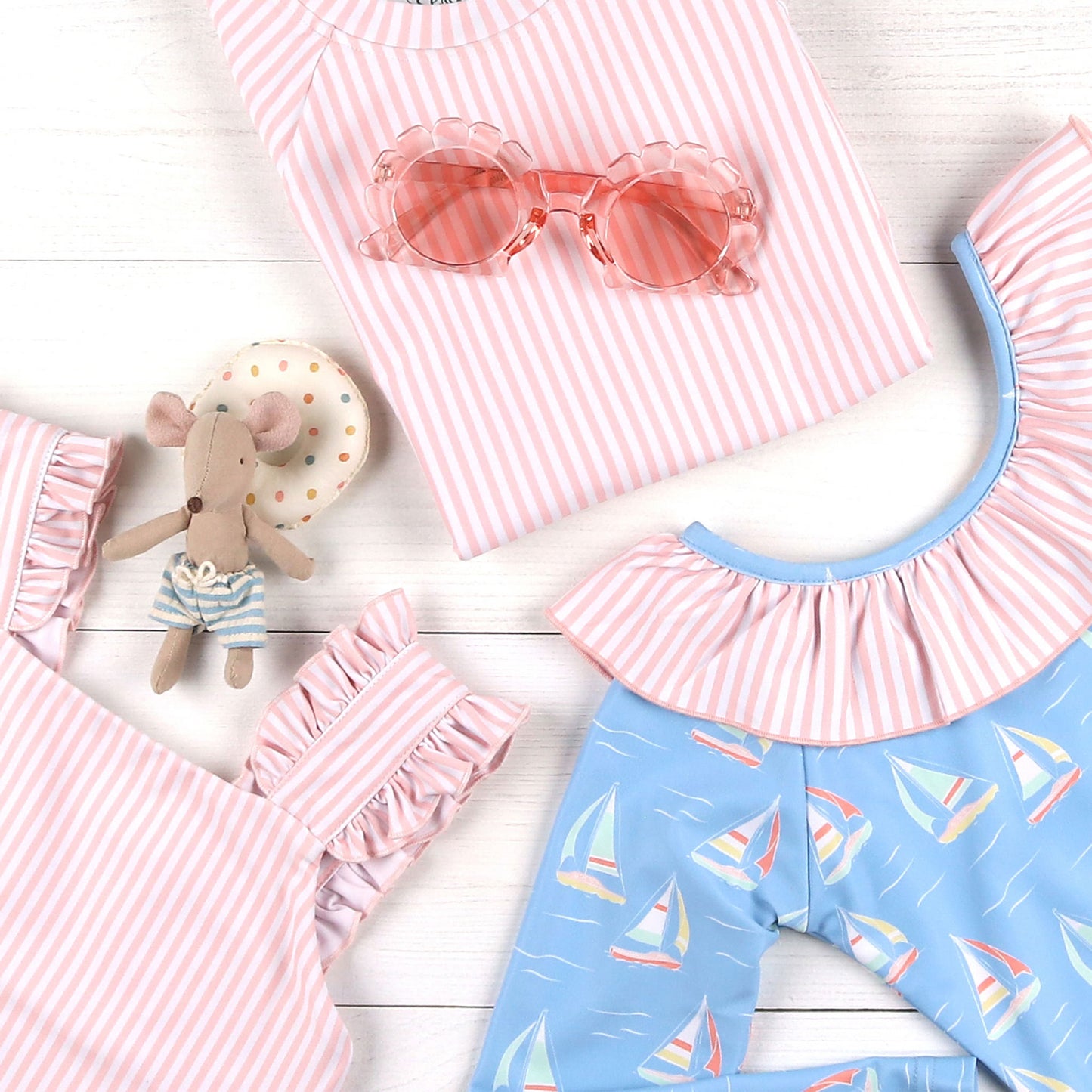 flatlay of sunglasses, kids swimwear and Catalina One-Piece Rash Guard