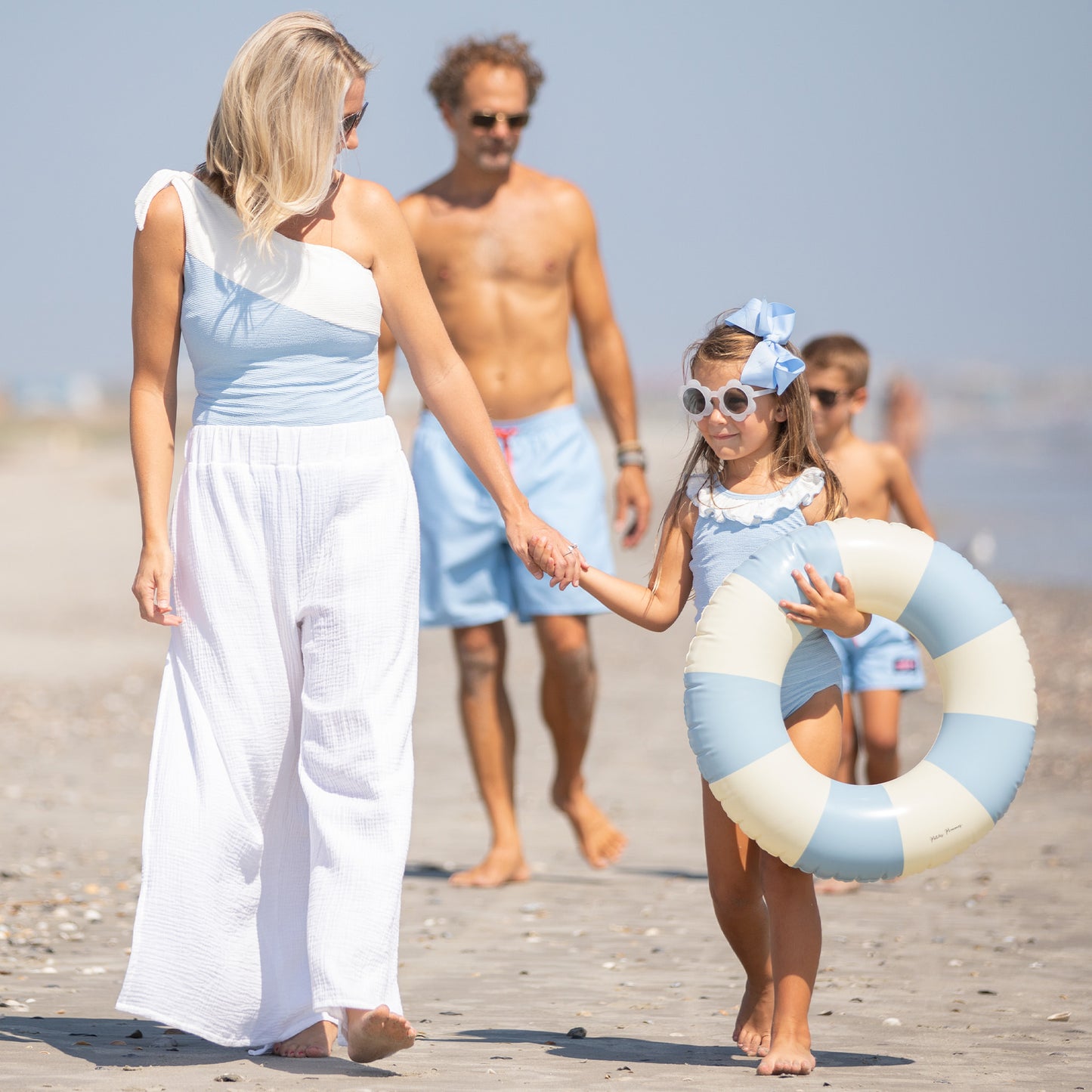 family walking down the beach and mom wearing Skye Women's Suit