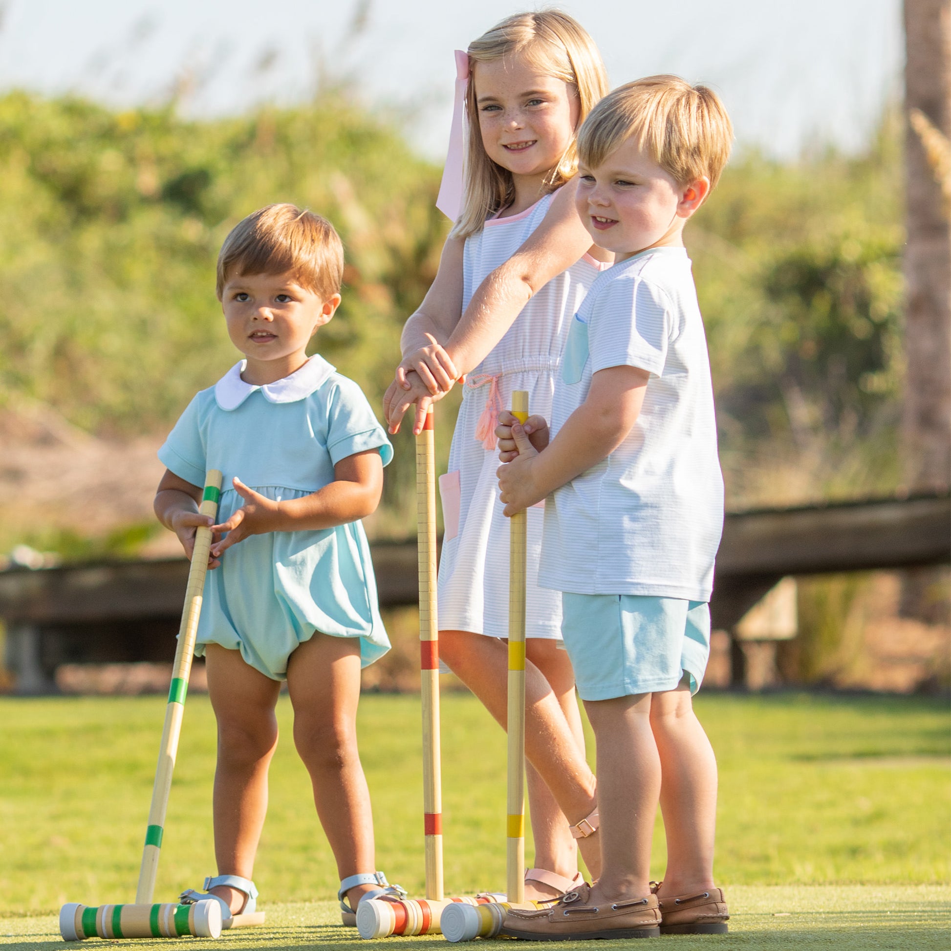 three kids playing croquet