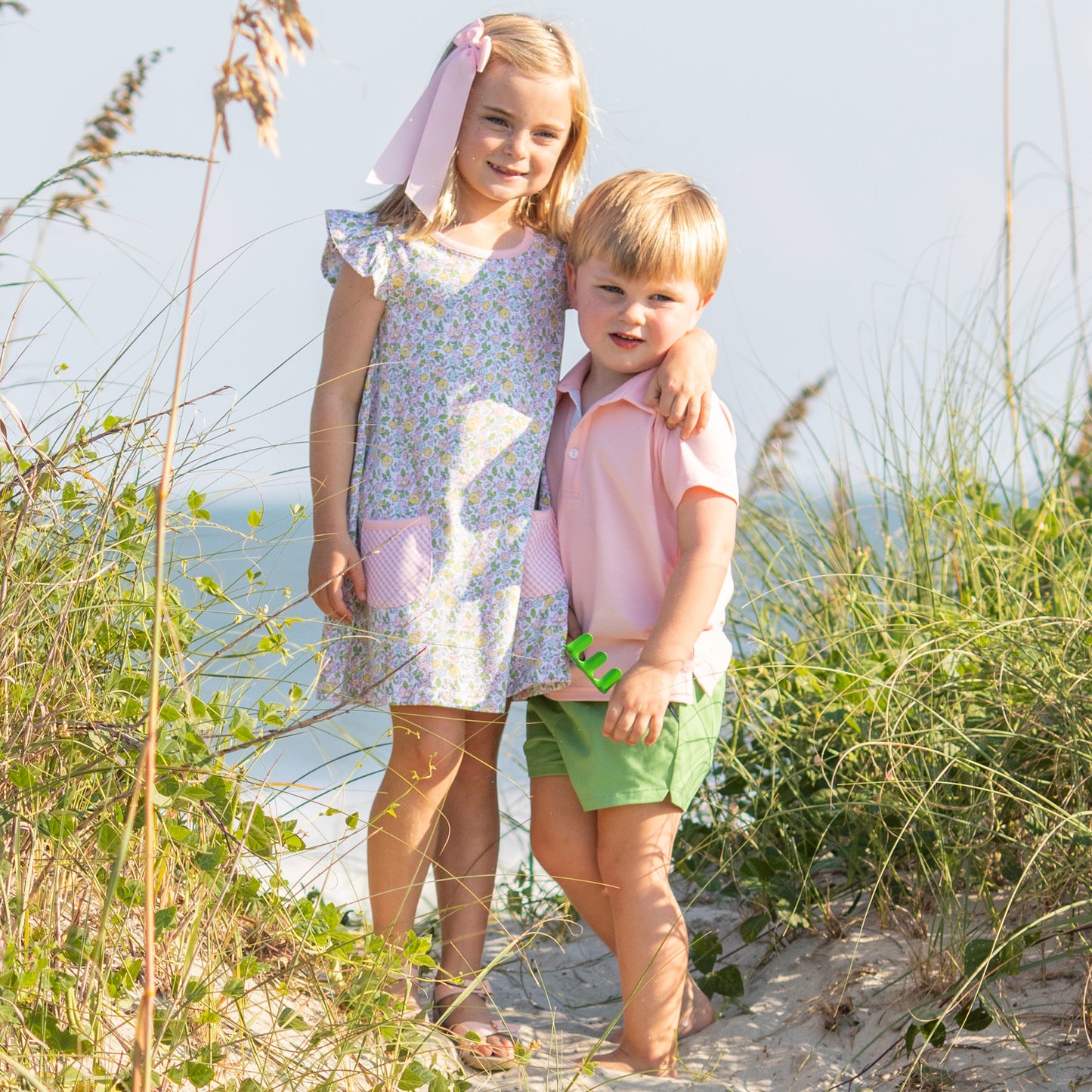 brother wearing a Pink Cotton Knit Polo hugging his sister on the beach