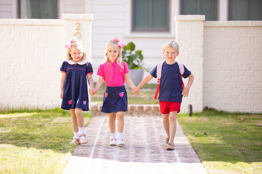 three kids holding hands with a backpack - back to school clothes