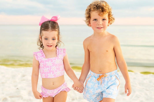 little boy and little girl holding hands on the beach