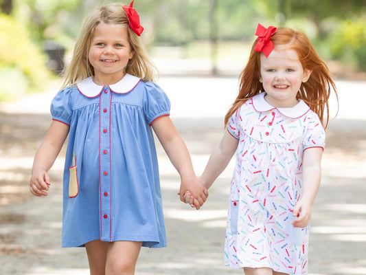 2 little girls holding hands in adorable fall outfits