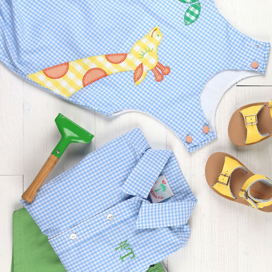 Monogrammed Kid’s Clothing Guide - flatlay of kids clothes and one of the shirts is monogrammed