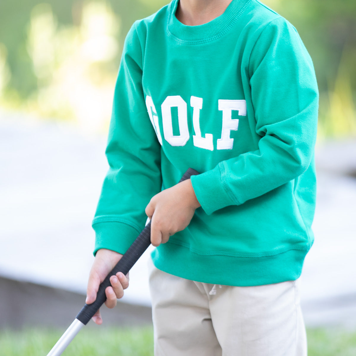 Close-up of green Golf Sweatshirt with white applique