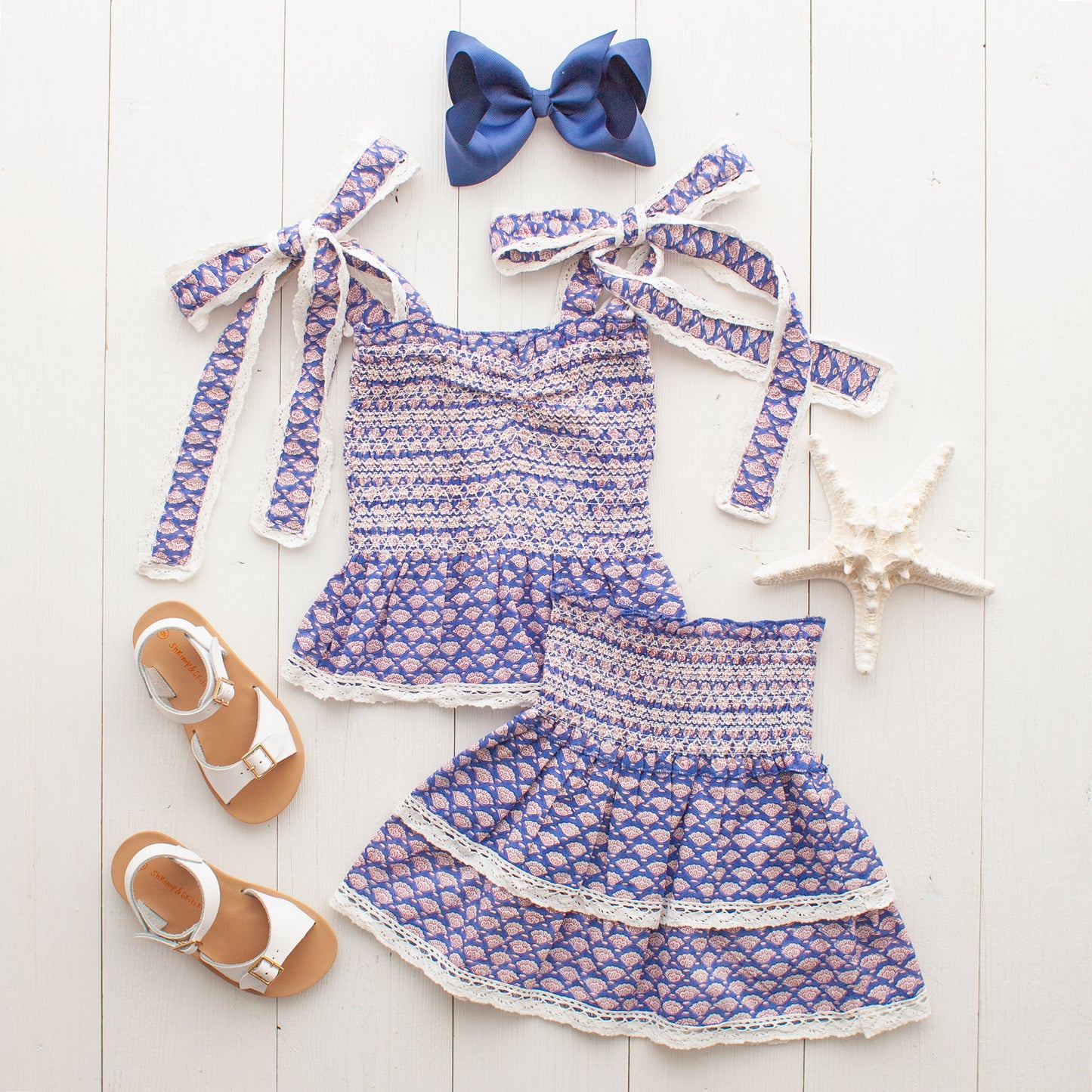 Bahama Blue Girl's Top flatlay with a blue bow and white sandals