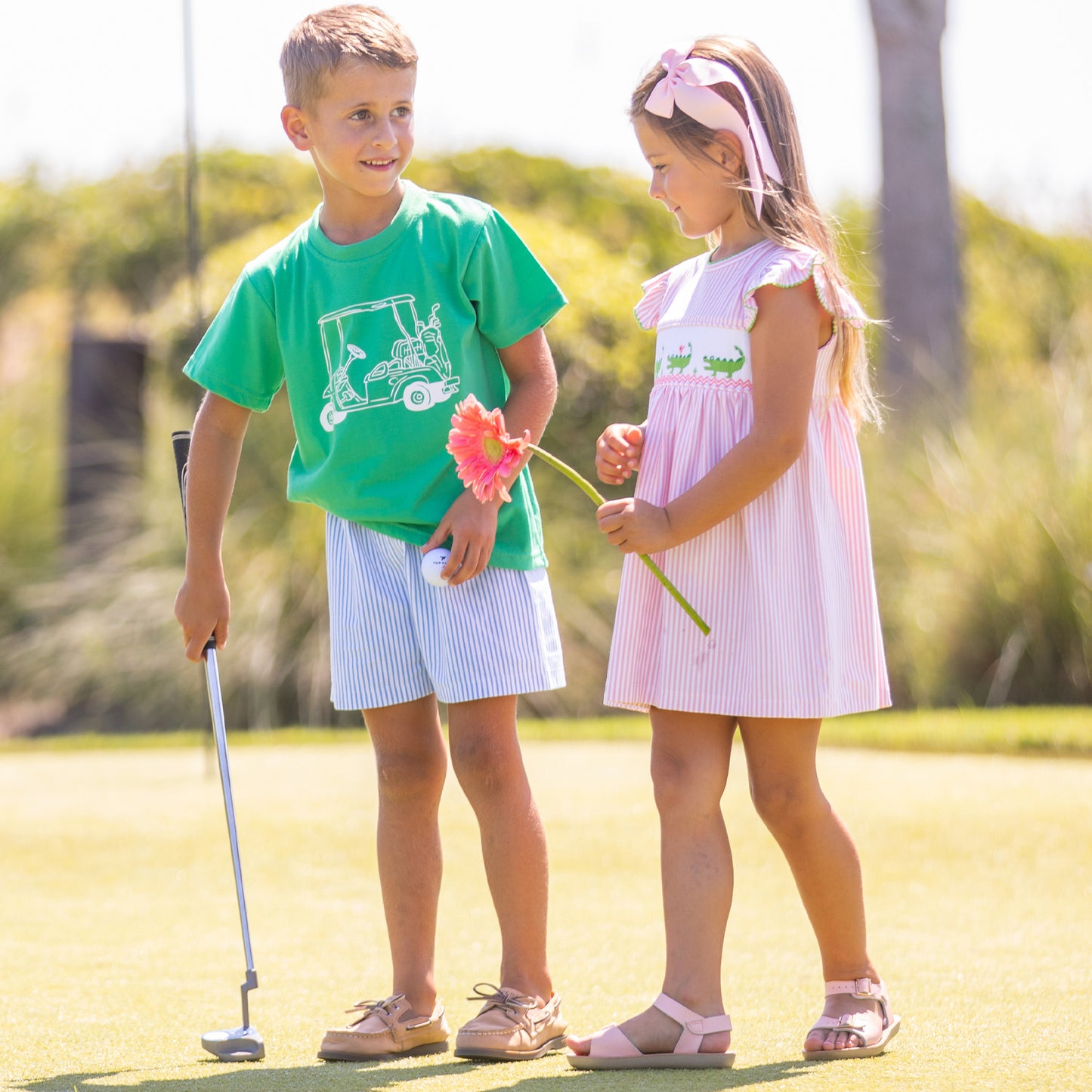 little boy and little girl playing golf