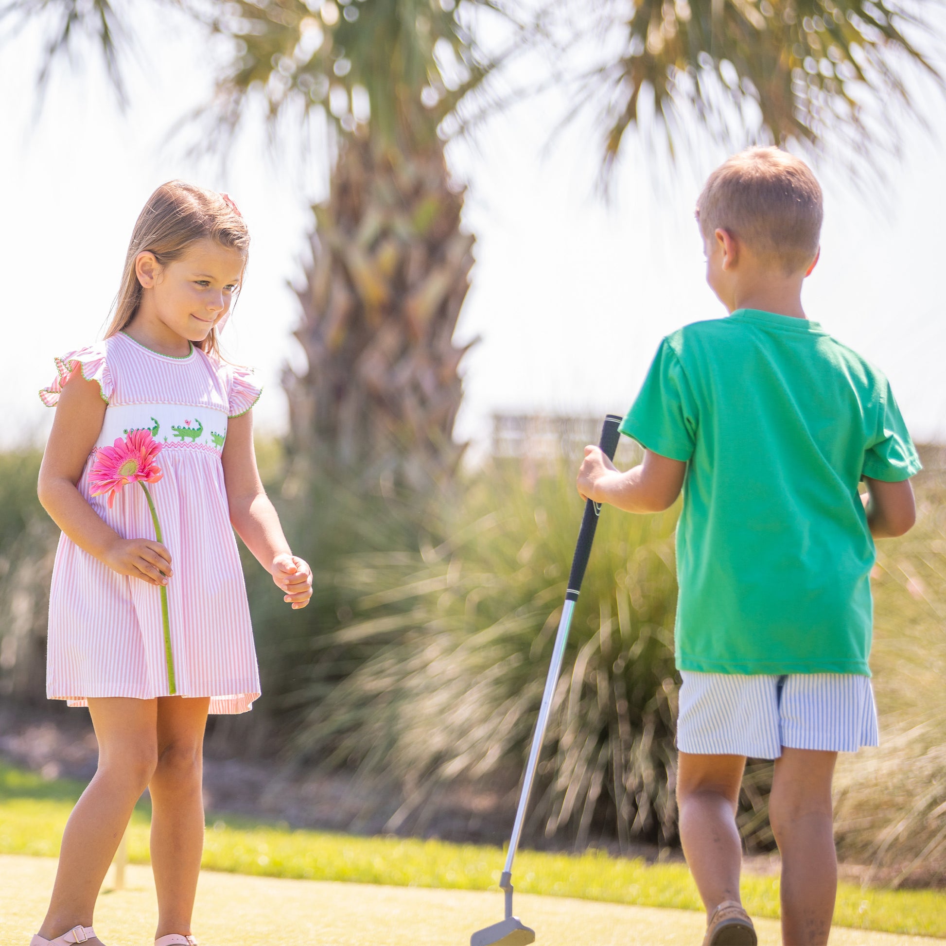 little boy wearing Kiawah Blue Stripe Shorts playing golf with a little girl