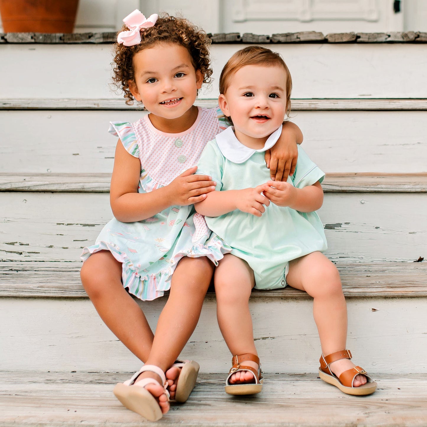 little girl wearing Girl's Beach Club Swing Top sitting on the steps with a little boy