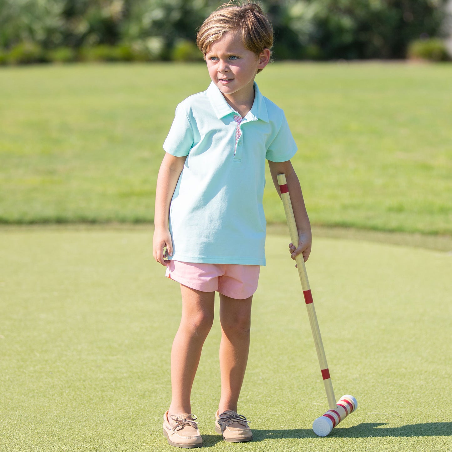 little boy wearing an holding a croquette raquet