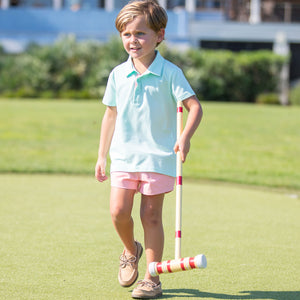 little boy holding a croquet racquet wearing an Aqua Polo Shirt