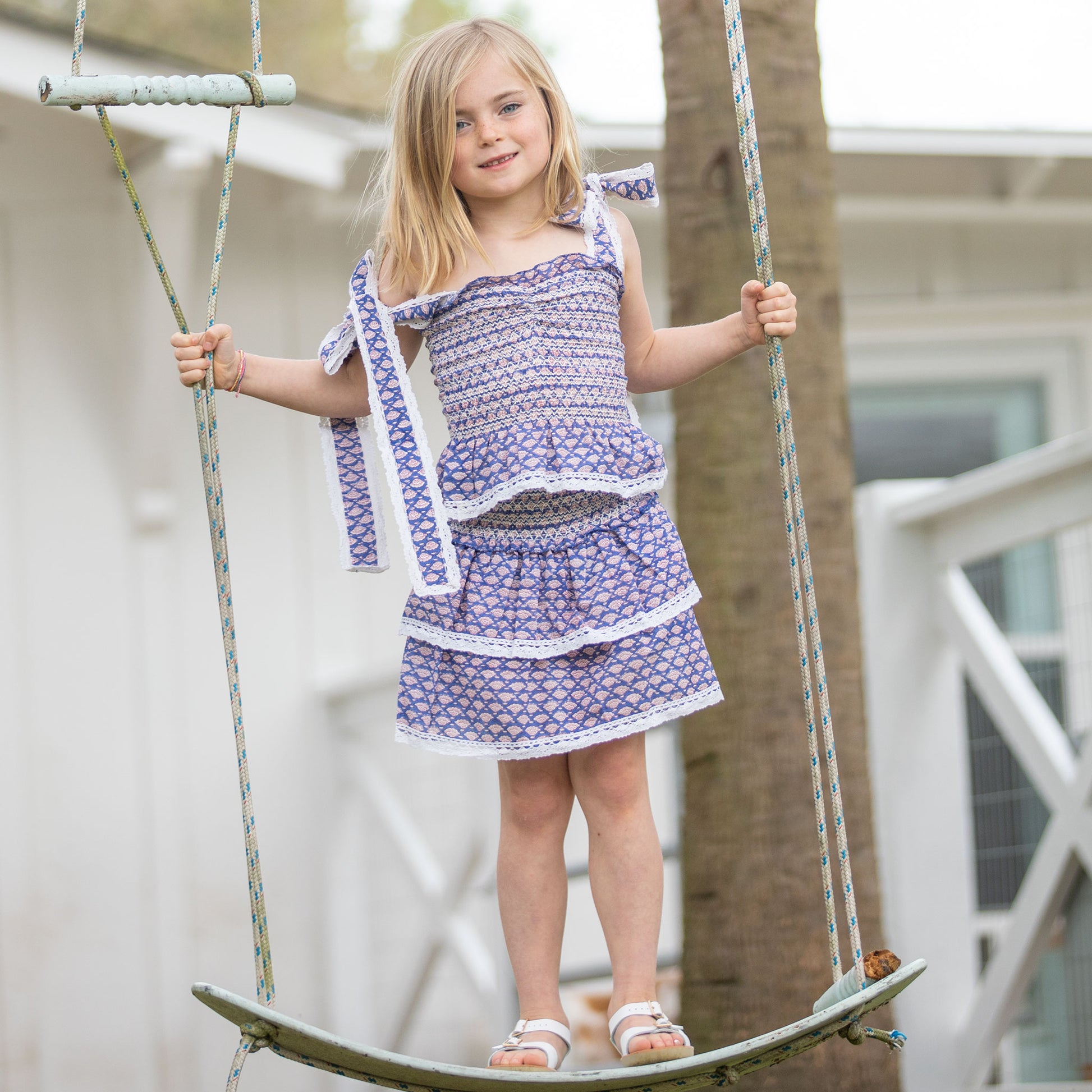 little girl wearingg Bahama Blue Girl's Top swing on a swurfer