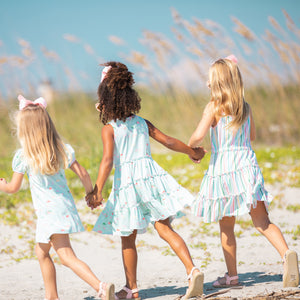three little girls on the beach one is wearing Beach Club Stripe Tier Dress