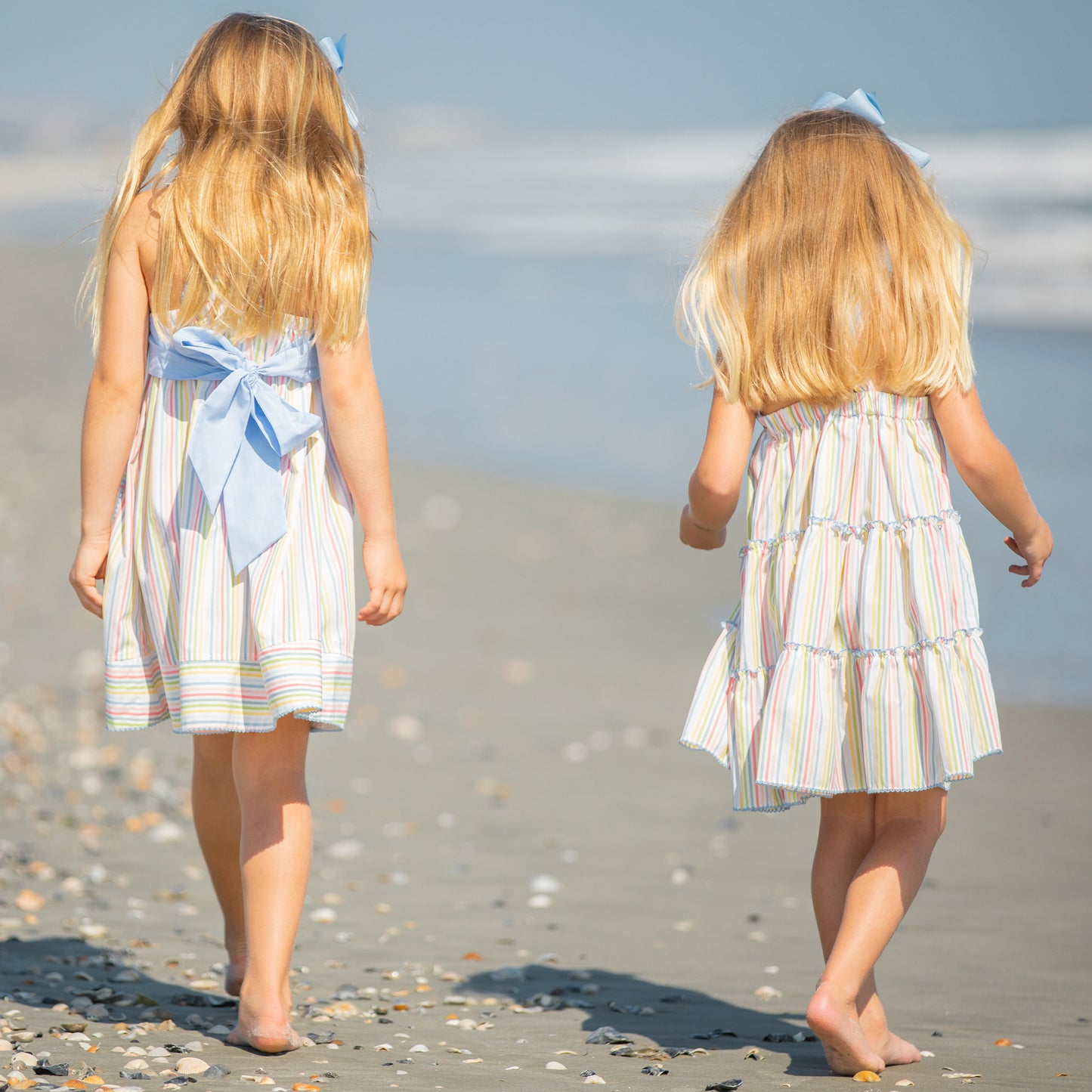two little girls walking down the beach