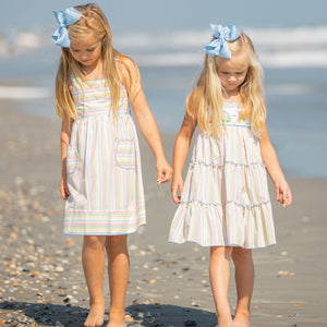 two little girls walking on the beach looking at shells