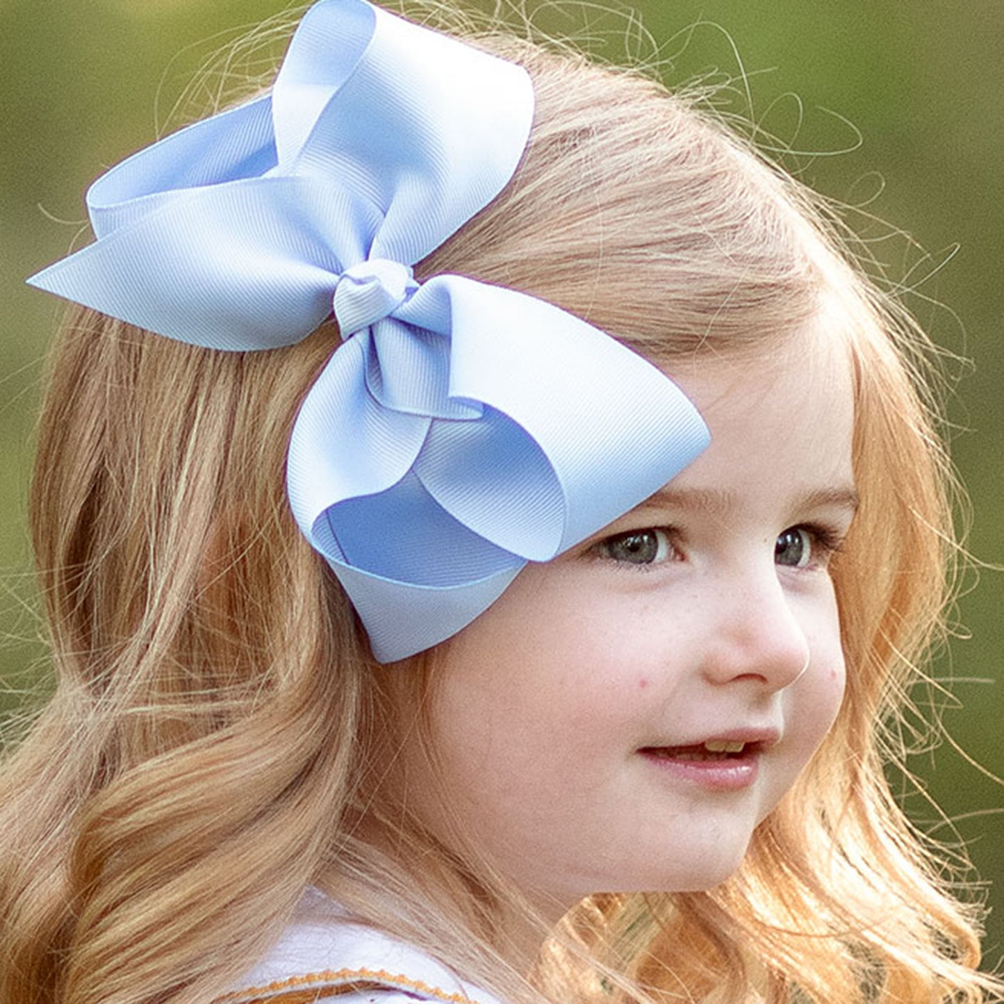 little girl wearing a Blue Bird Biggie Bow in her hair