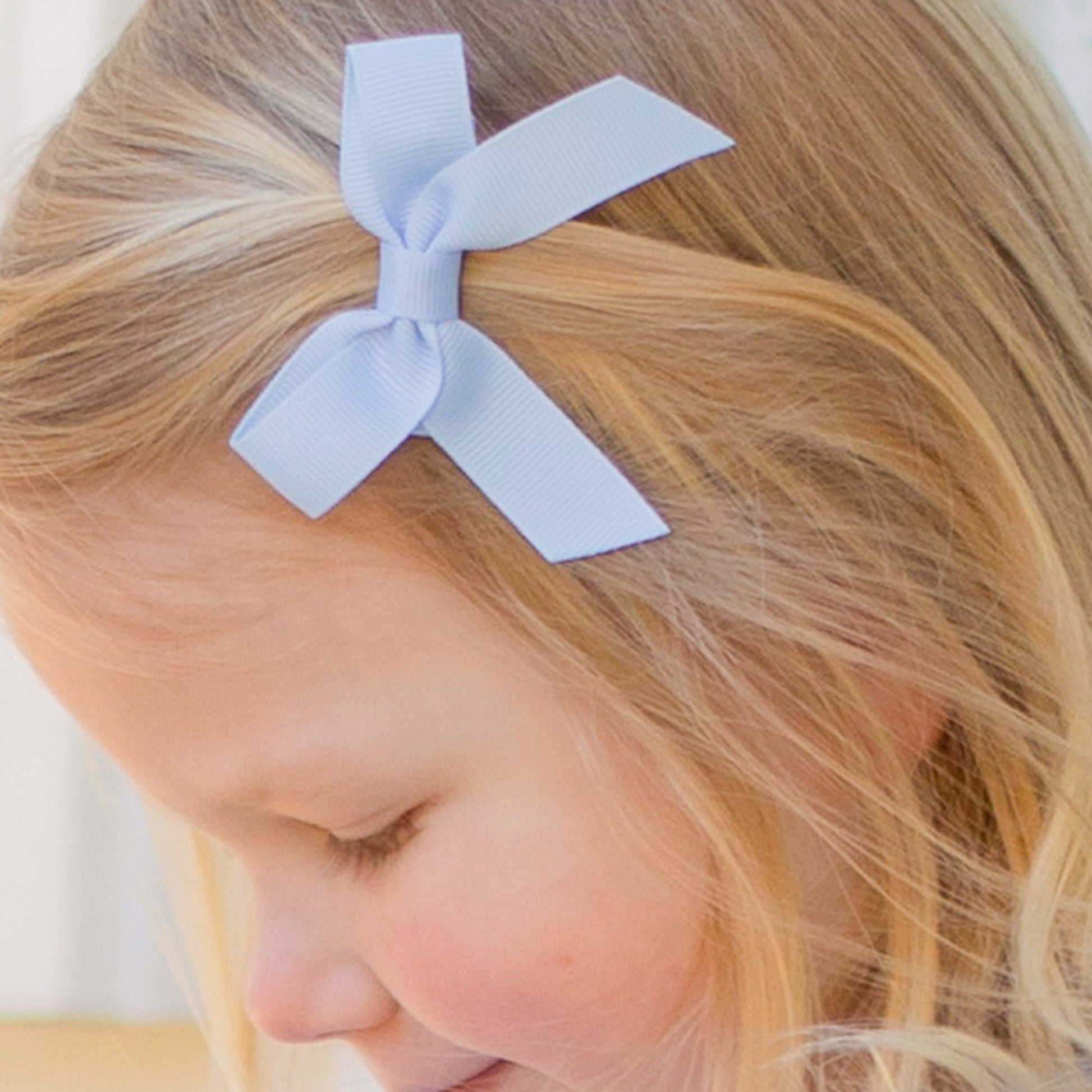 little girl wearing a Blue Bird Bitty Bow in her hair