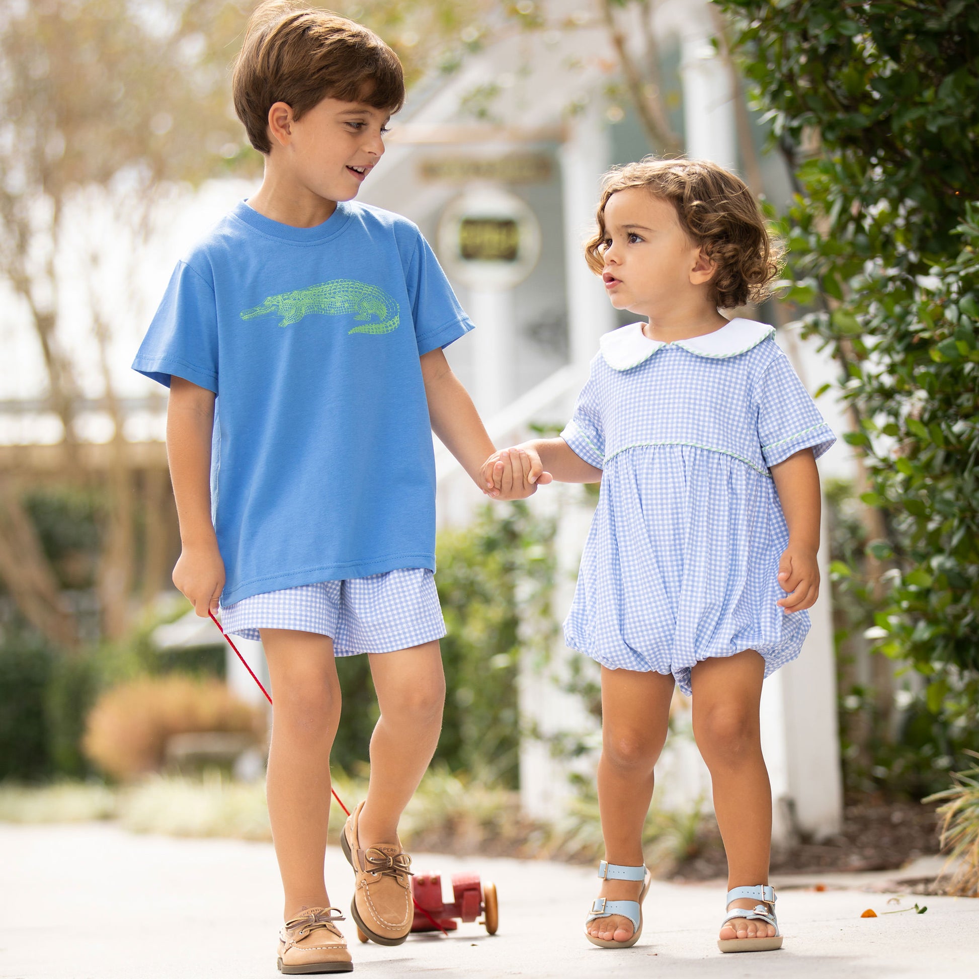 two little boys walking down the street one wearing Blue Check Knit Bubble