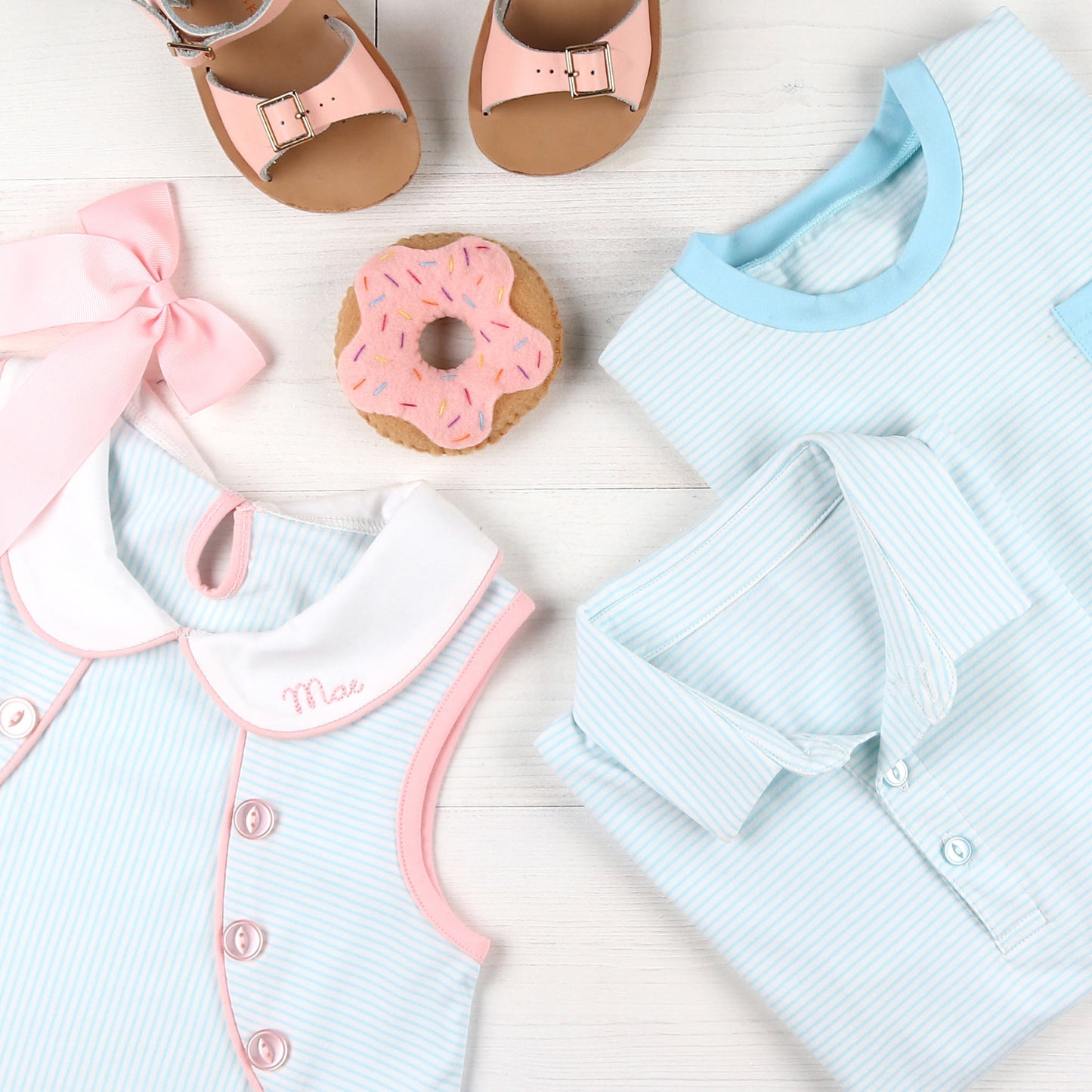 flatlay of Girls Tennis Club Eloise Dress, toy donut, striped polo, striped tshirt and pink sandals