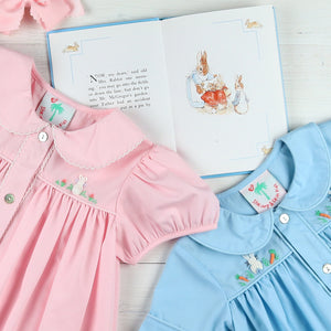 flatlay of a pink and blue dress and an Easter book