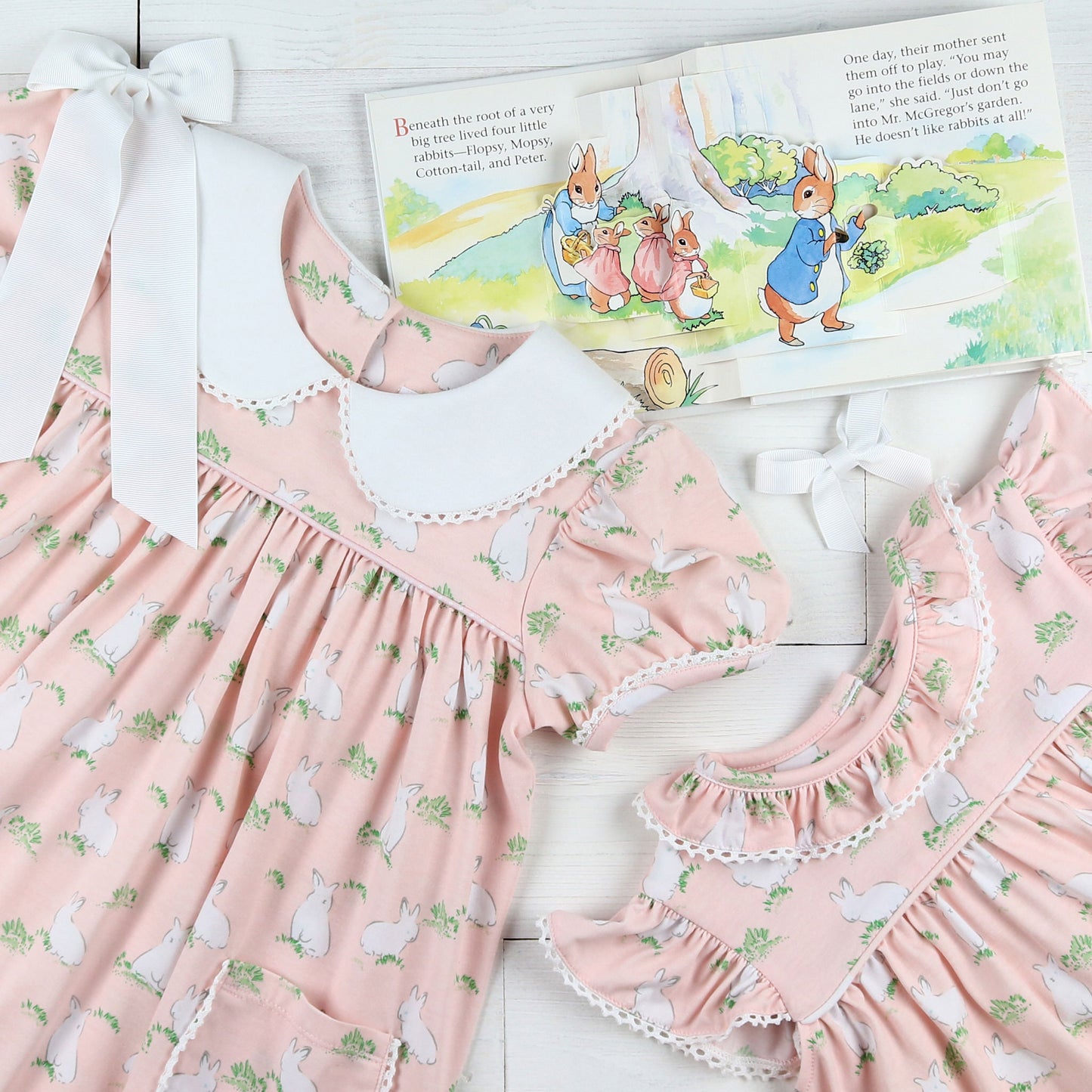 flatlay of Hippity Hoppity Knit Dress with a white bow and an Easter book