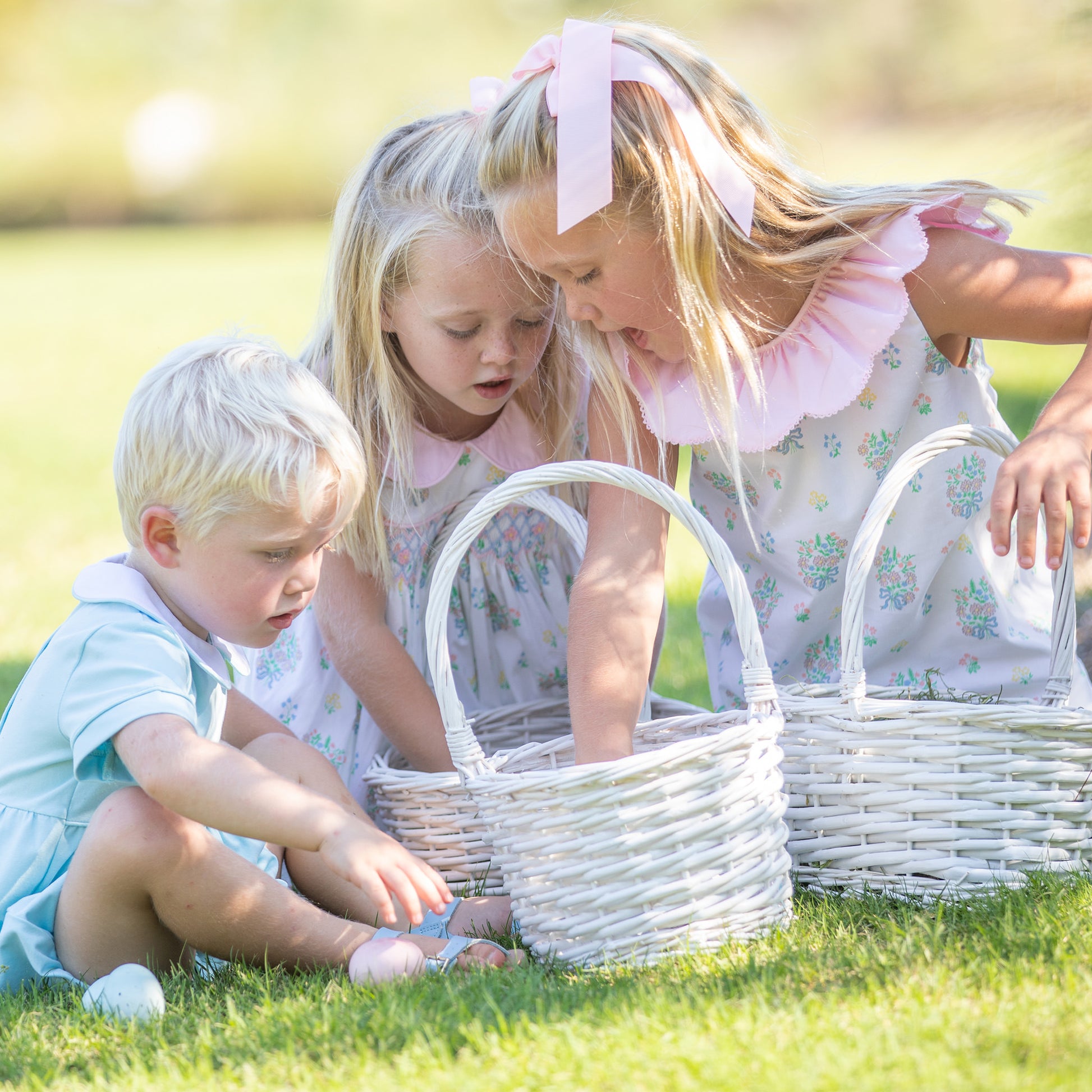 2 little girls and a little boy at an Easter egg hunt