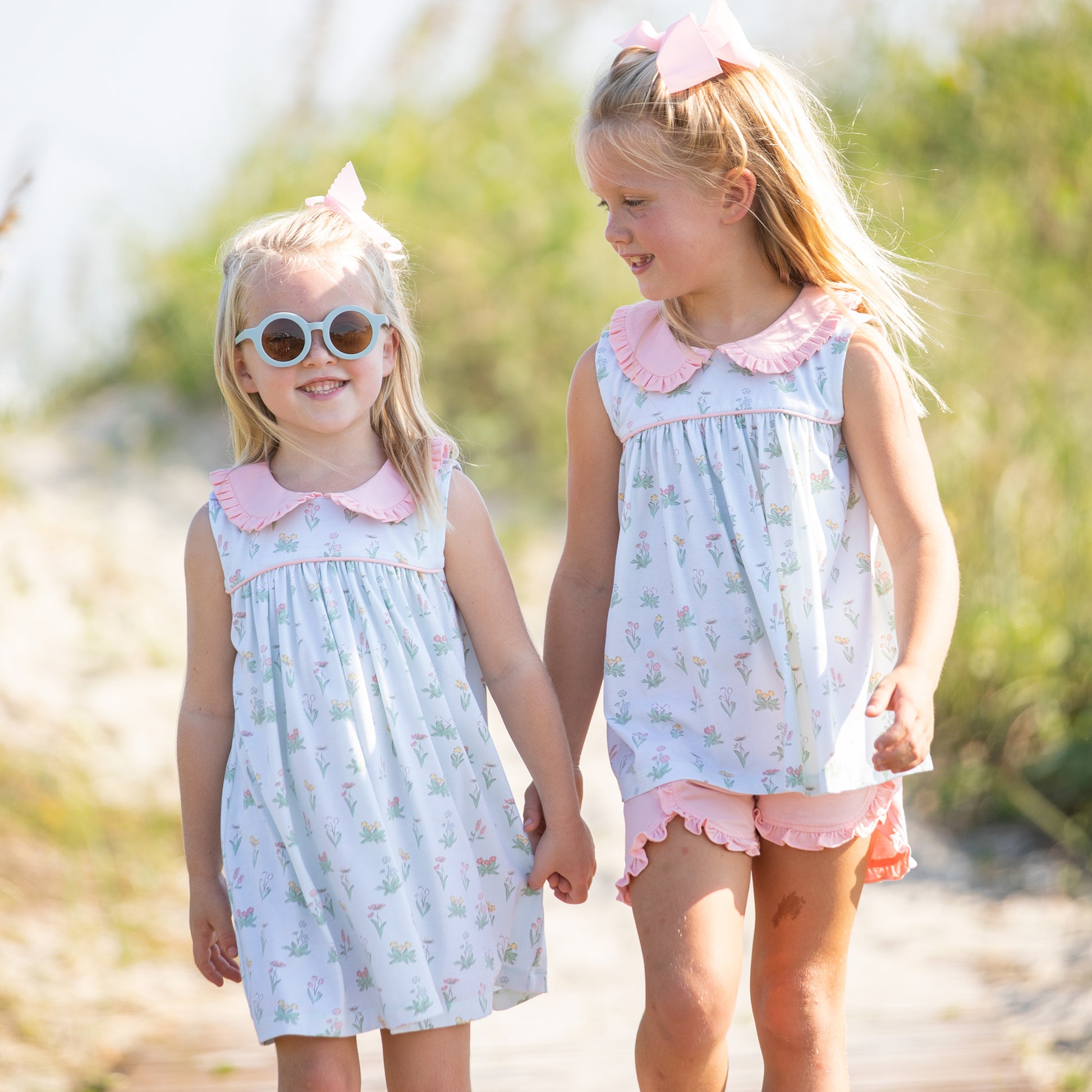 two little girls holding hands walking on the beach one is wearing Girl's Secret Garden Dress