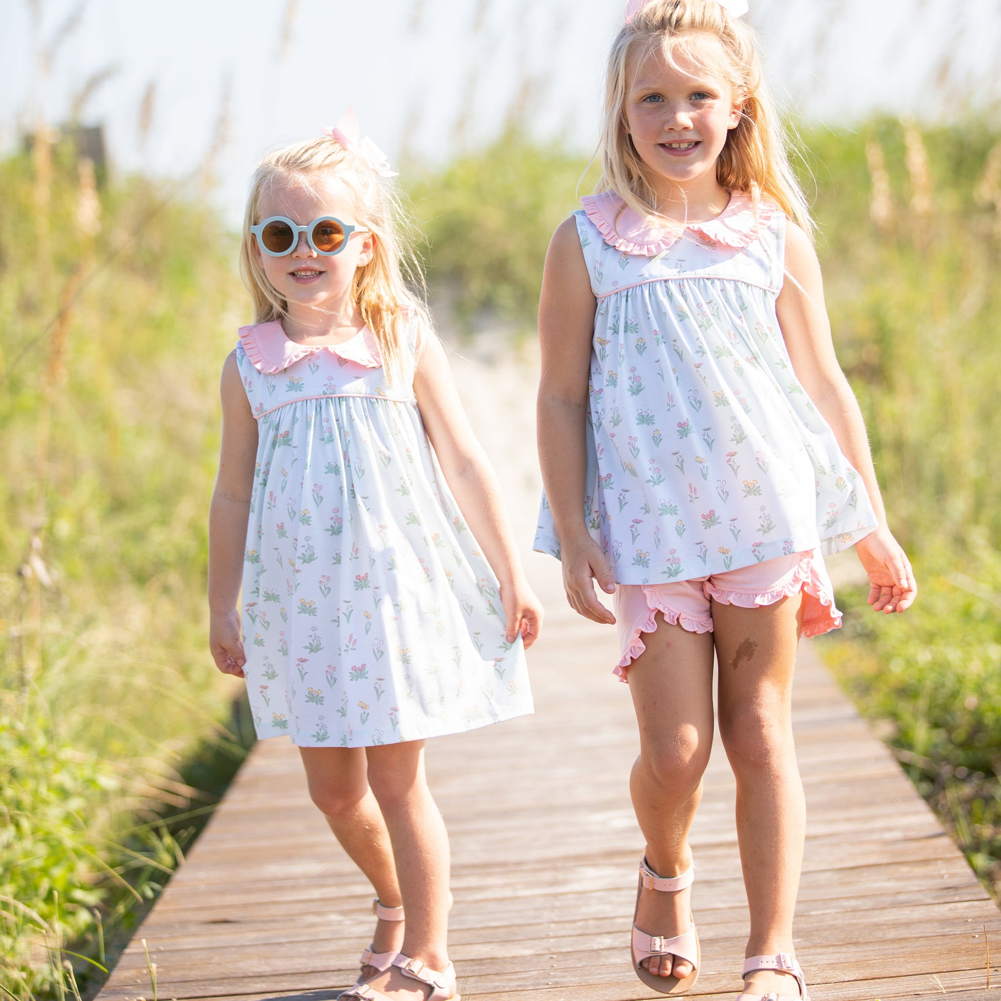 a little girl wearing Girl's Secret Garden Dress walking down the boardwalk with another little girl