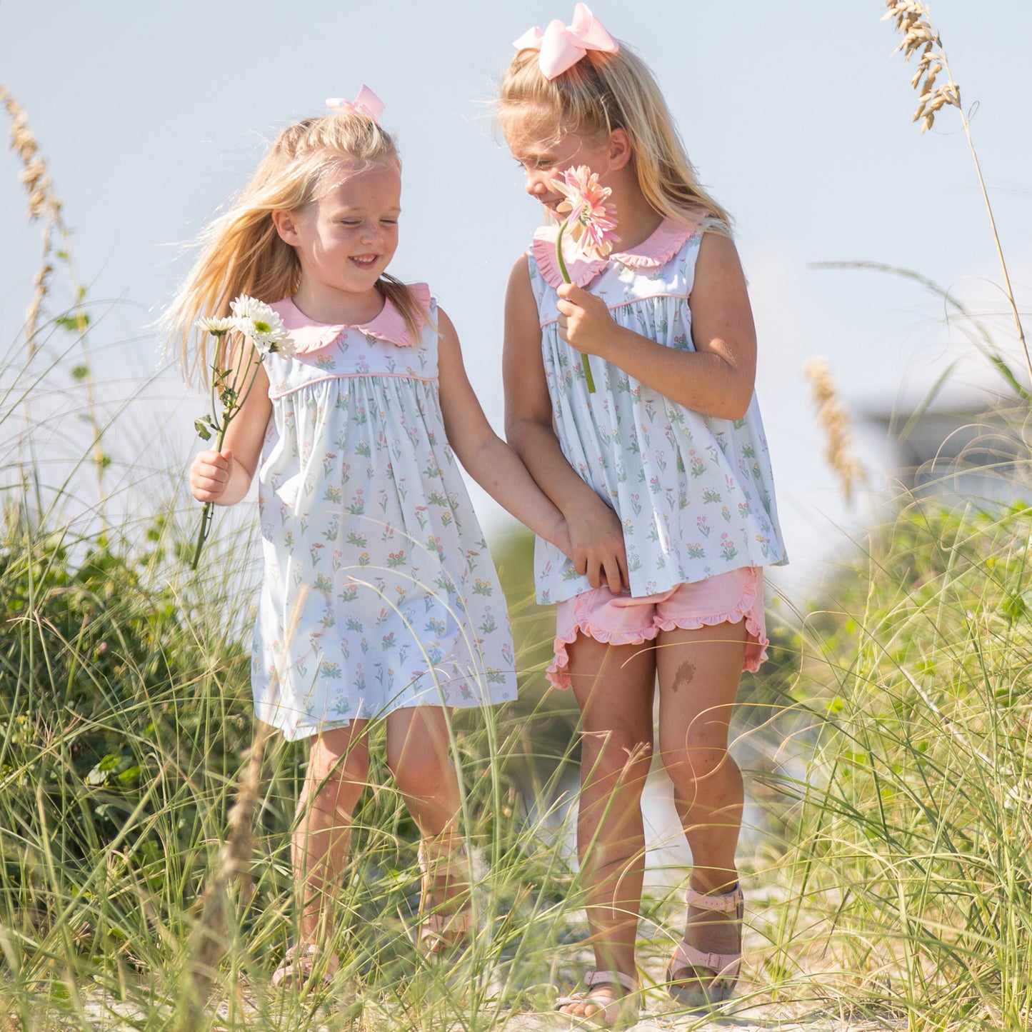 little girls smiling and laughing in the dunes at the beach