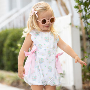 little girl walking down the sidewalk in pink sunglasses
