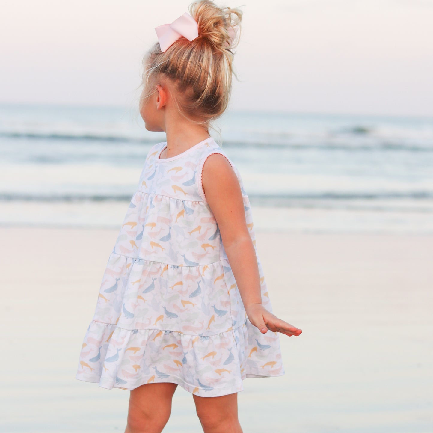 little girl looking backwards at the beach