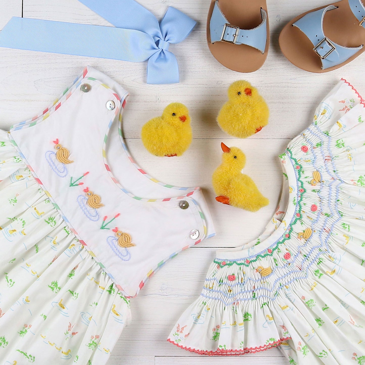 flatlay of dresses, blue bow, and blue sandals