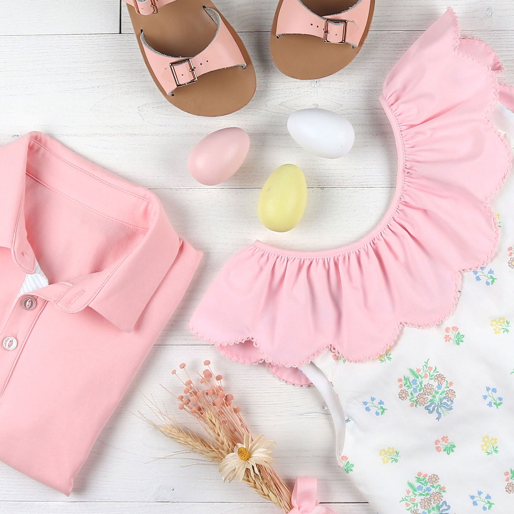 flatlay of a pink polo, pink sandals and a dress