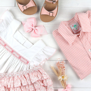 flatlay of pink gigham oxford, smocked dress and pink sandals