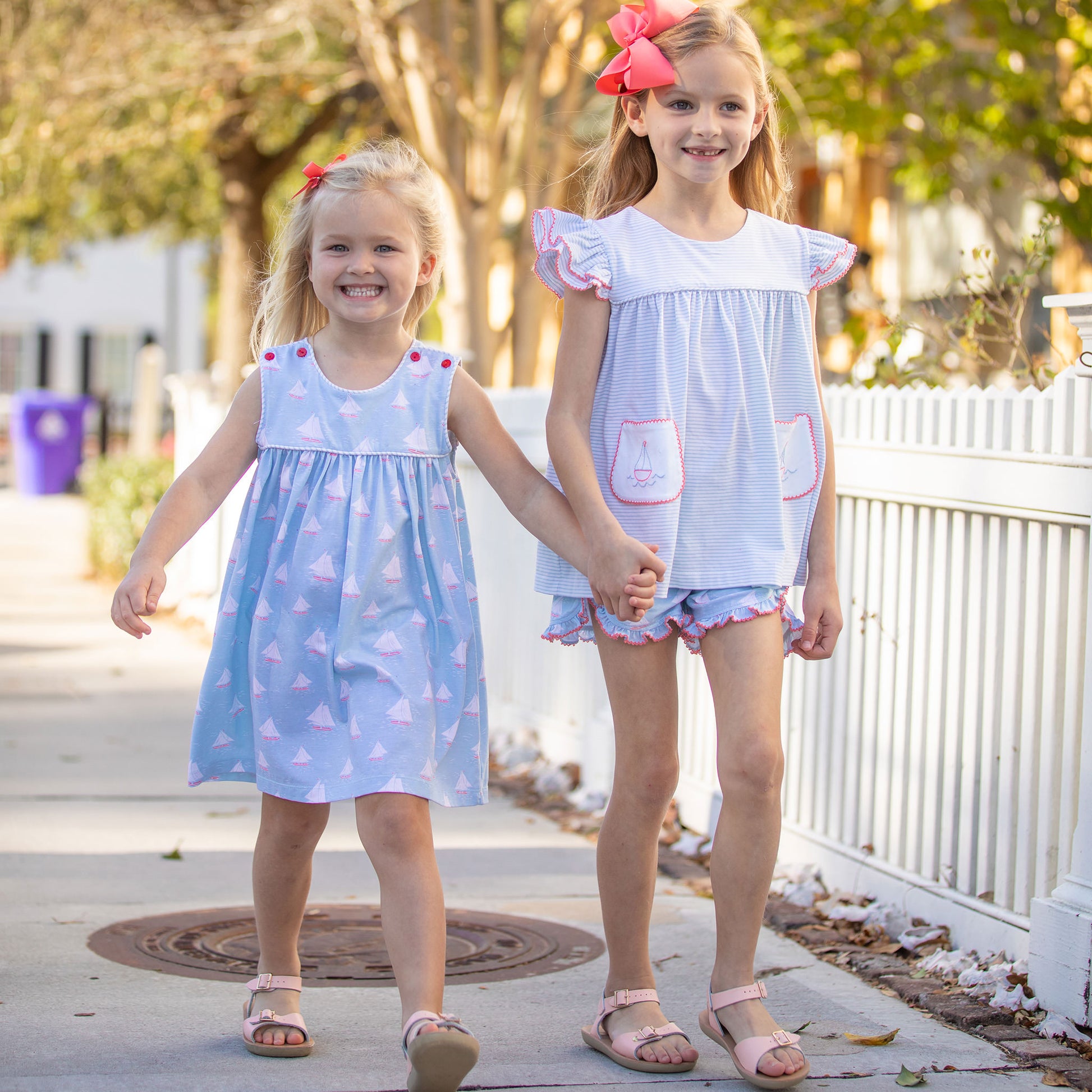two little girls walking down the sidewalk