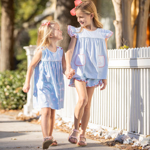 two little girls walking down the sidewalk