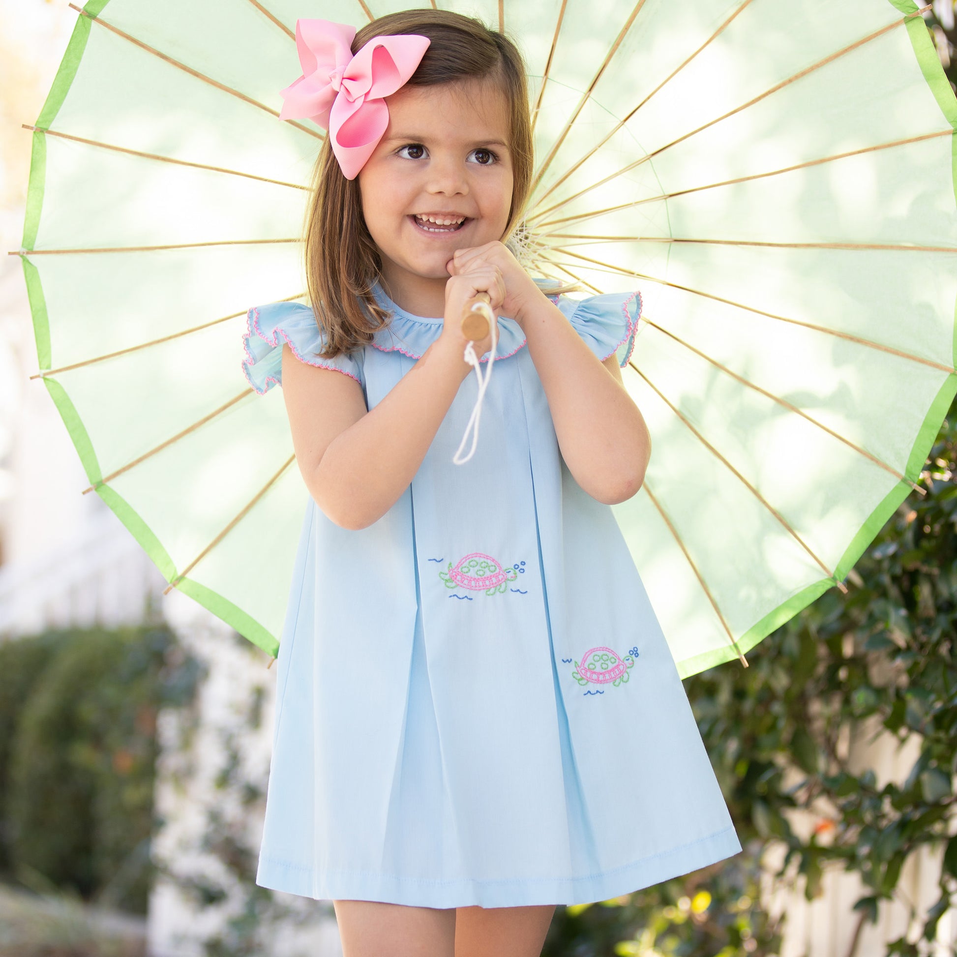 little girl in Turtles All the Way Embroidered Dress and parasol